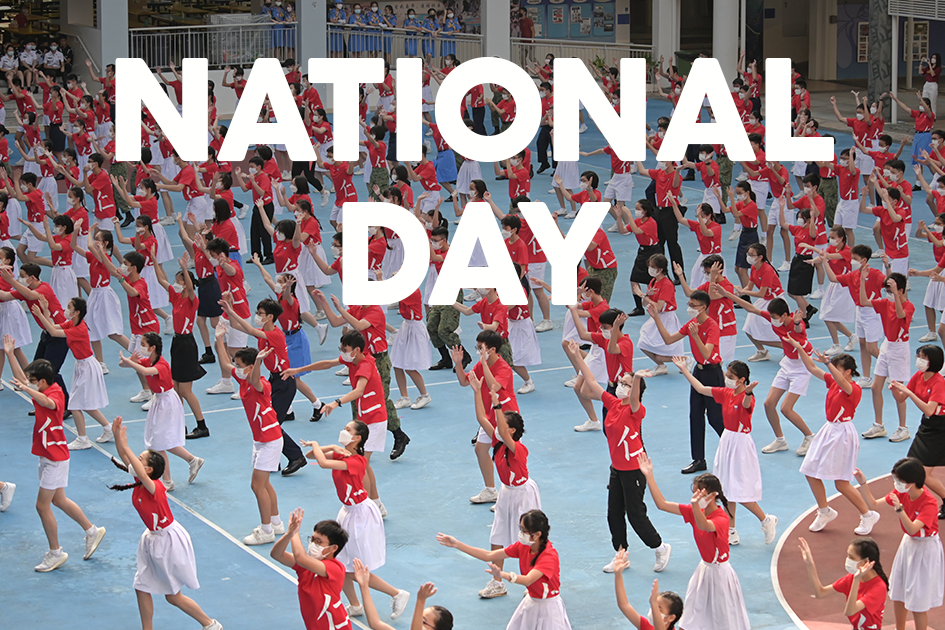 Students in red and white uniforms perform a coordinated dance at a National Day celebration.