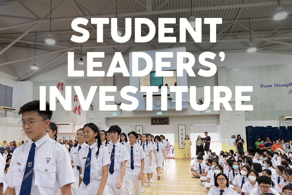 Students in white uniforms march through a school hall during a Student Leaders' Investiture ceremony.