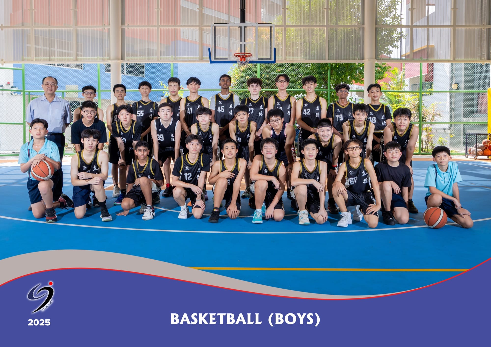 The Basketball (Boys) team in black and gold jerseys with their teacher-in-charge, on the school's outdoor basketball court in 2025.