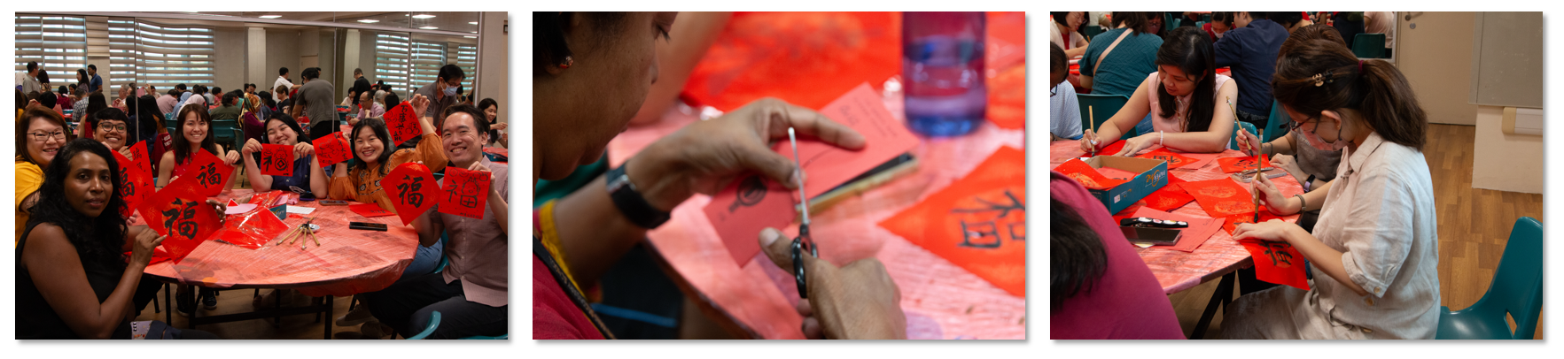People at tables holding and creating red Chinese calligraphy papers with the character Fu during a festive event.