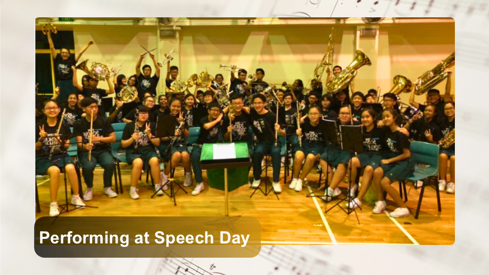 Group photo of symphonic band members on stage with their instruments after performing at Speech Day.