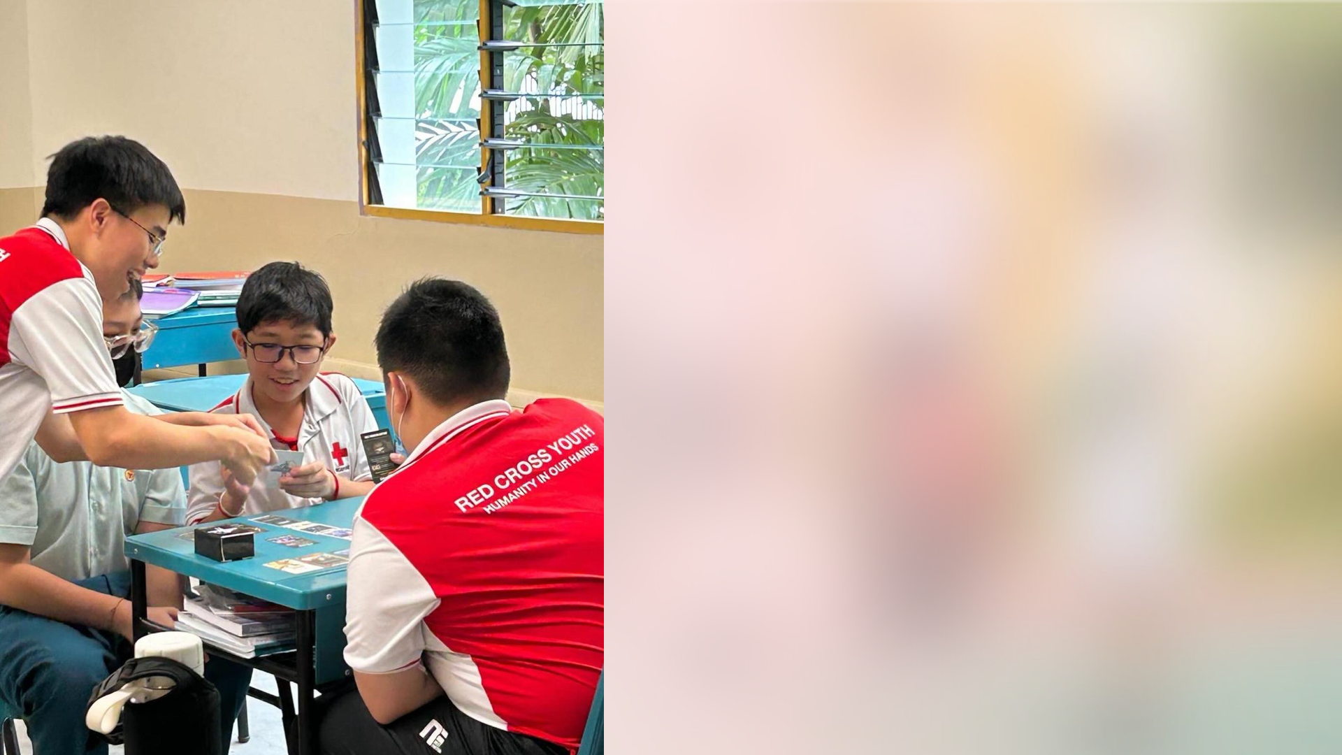 Red Cross Youth cadets playing an educational card game around a classroom table.
