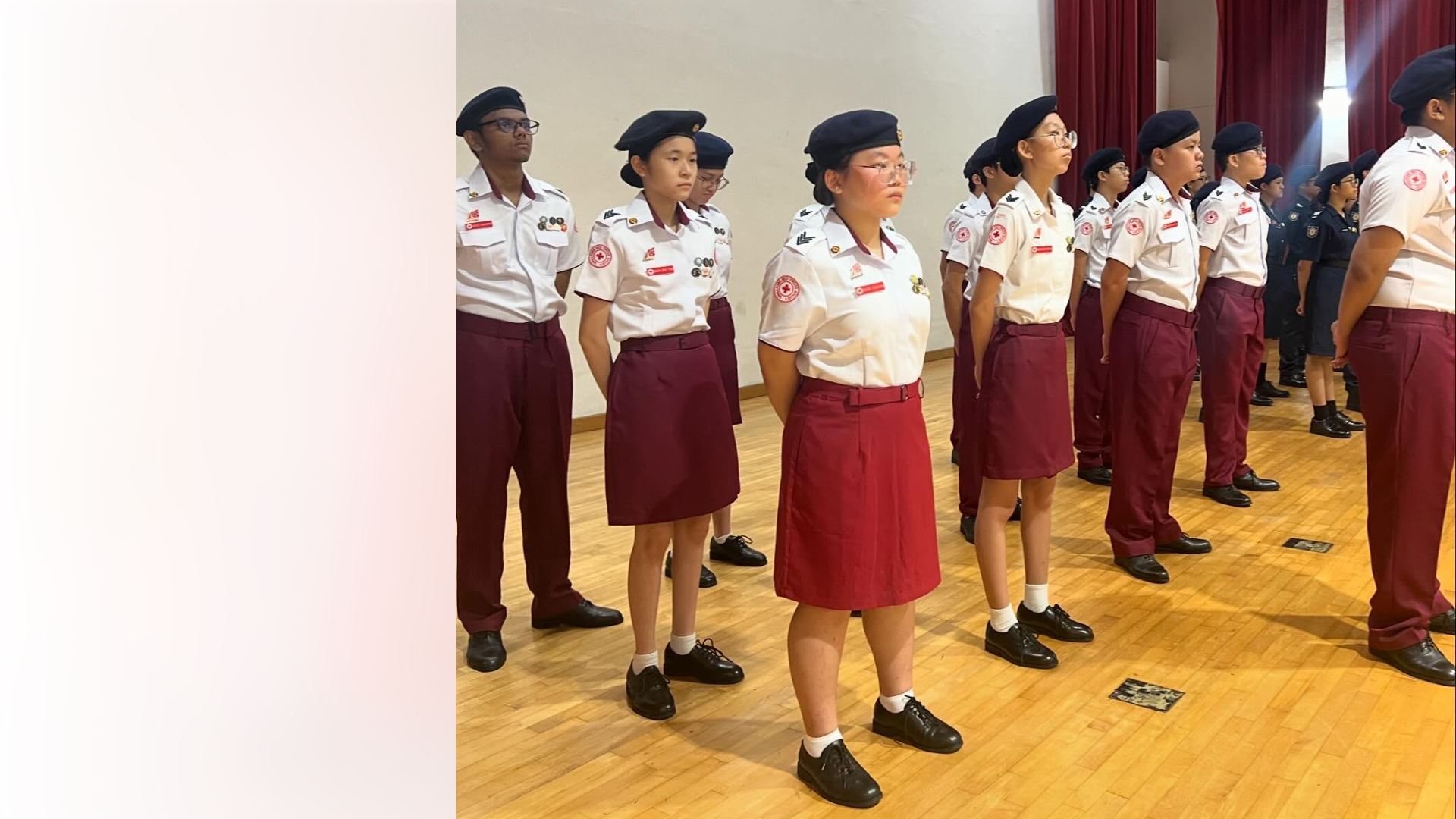 Red Cross Youth cadets standing at attention in full dress uniform during a parade ceremony.