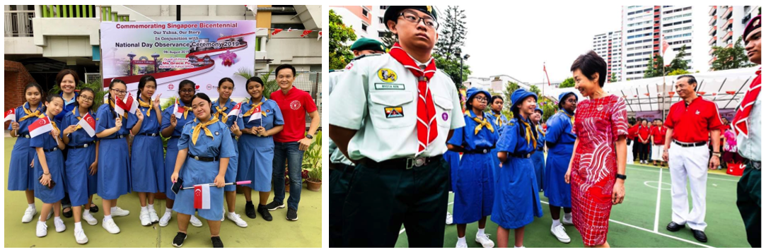 Students in blue scout uniforms hold Singapore flags at a National Day Observance Ceremony 2019 event.