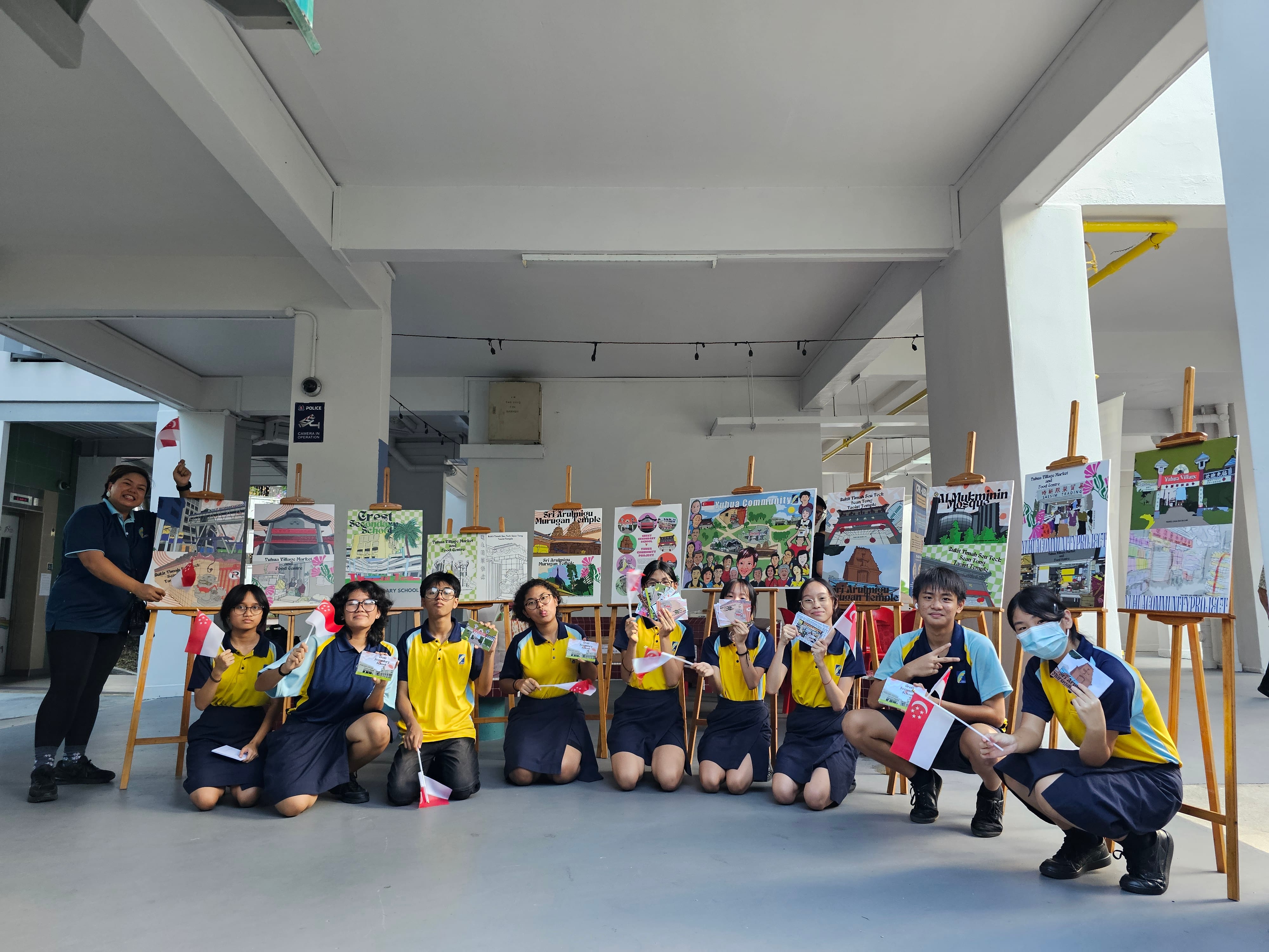 students posing in front of their artwork