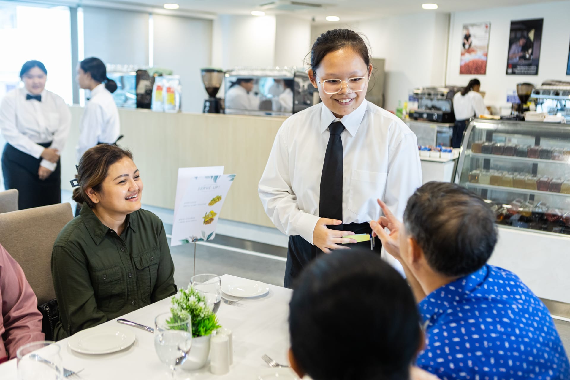 student talking to a table of diners