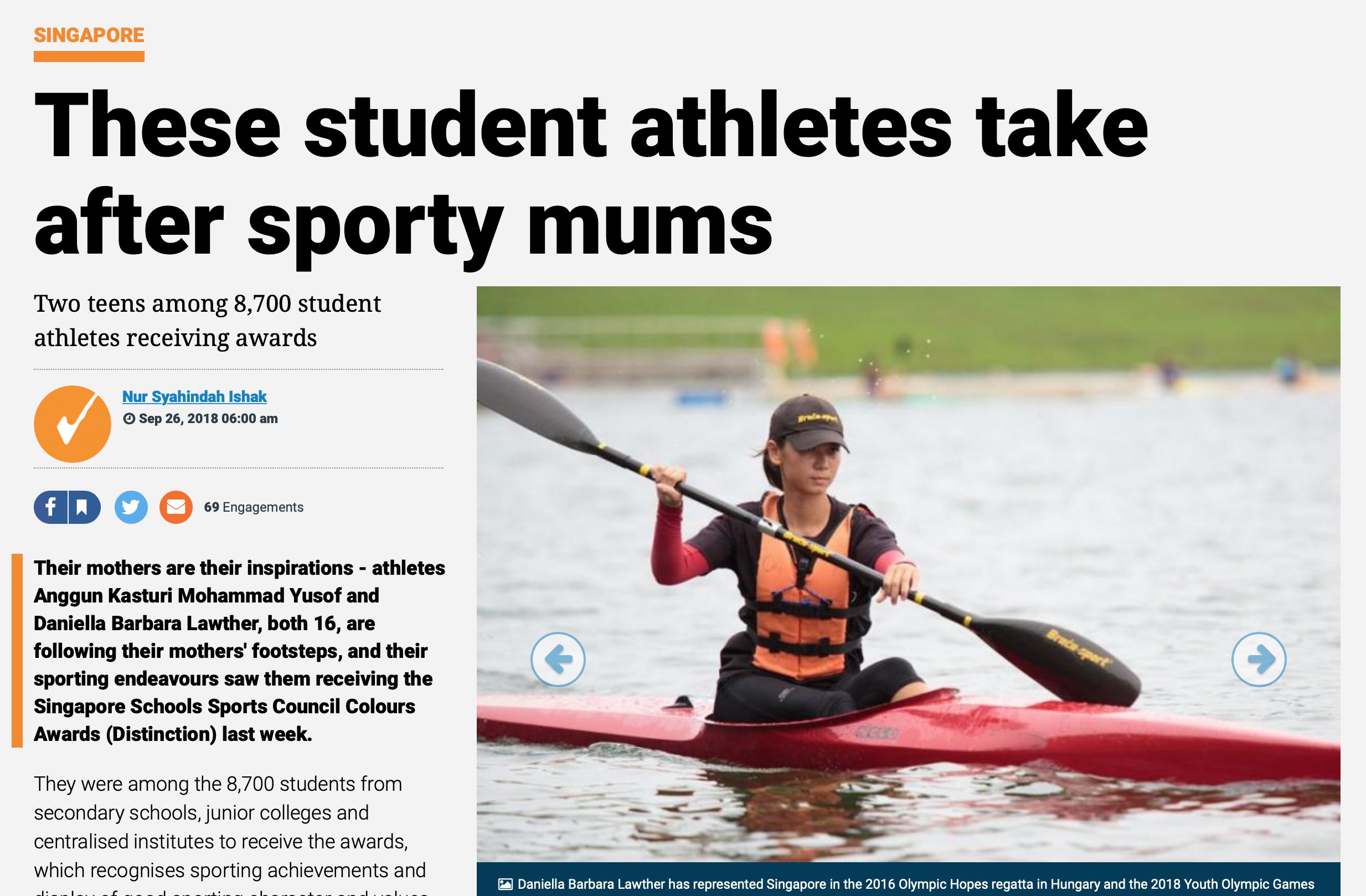 A young woman in an orange life jacket and cap paddling a red kayak on open water.