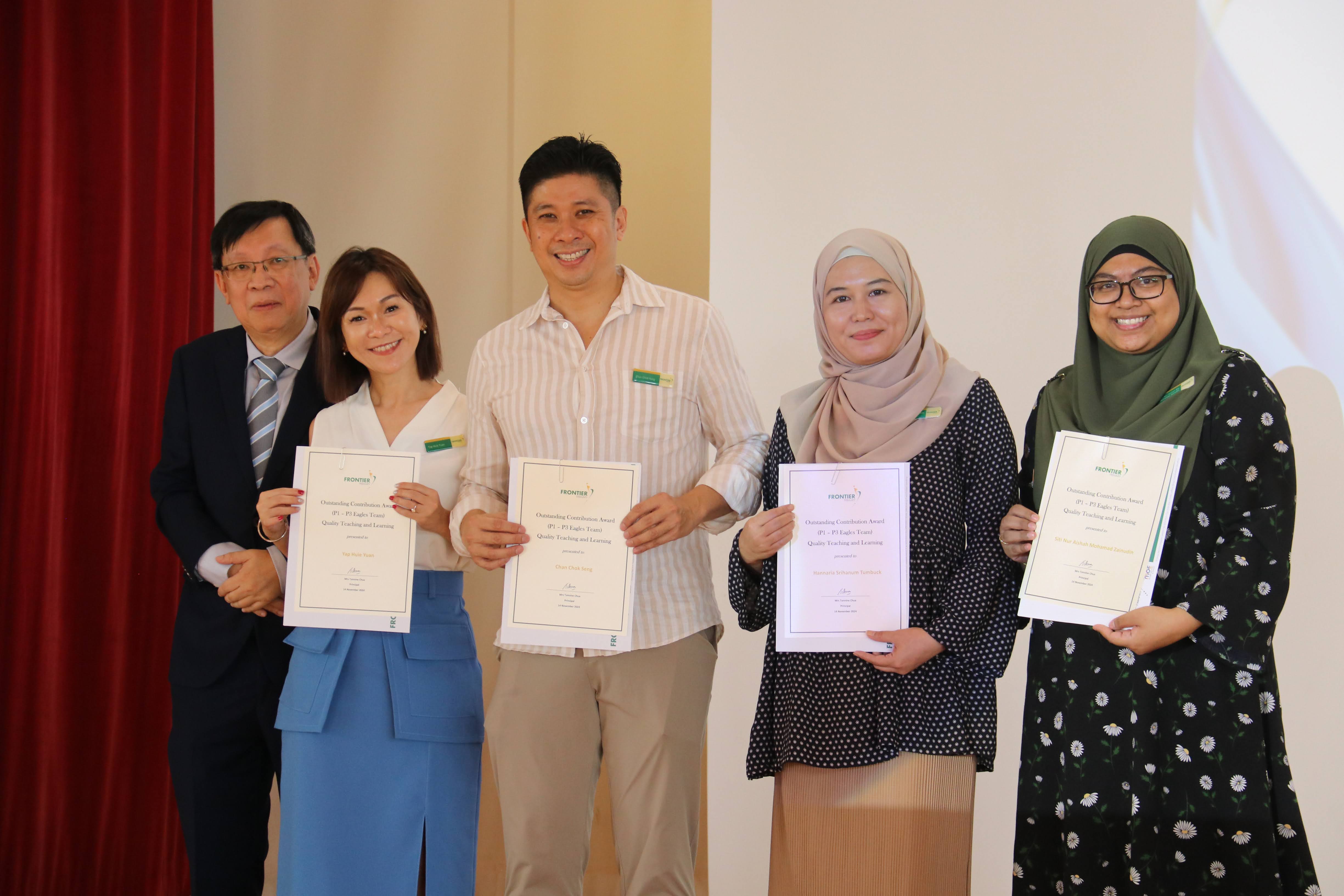 Five people stand together smiling, four holding Frontier Outstanding Contribution Award certificates.