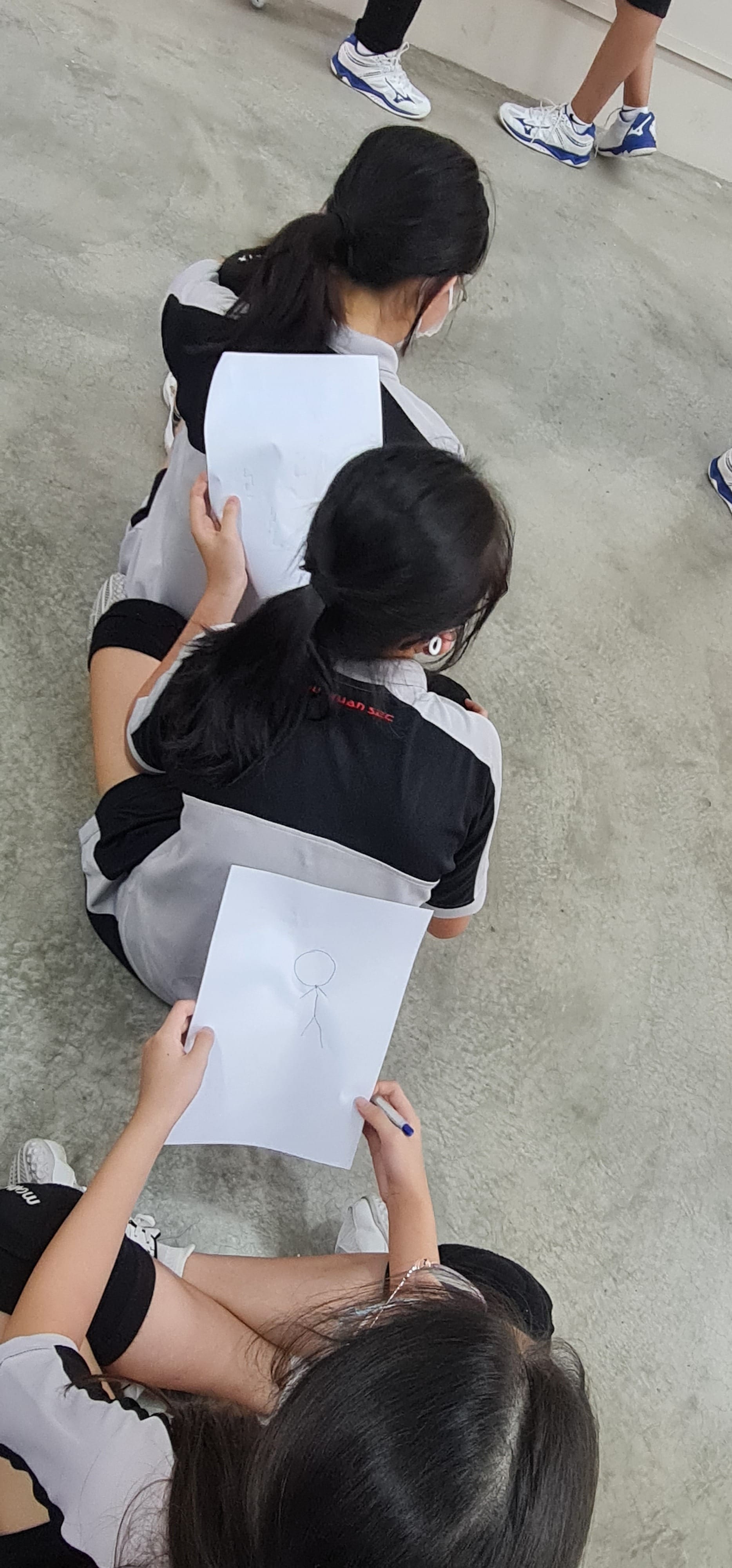 3 students holding a paper