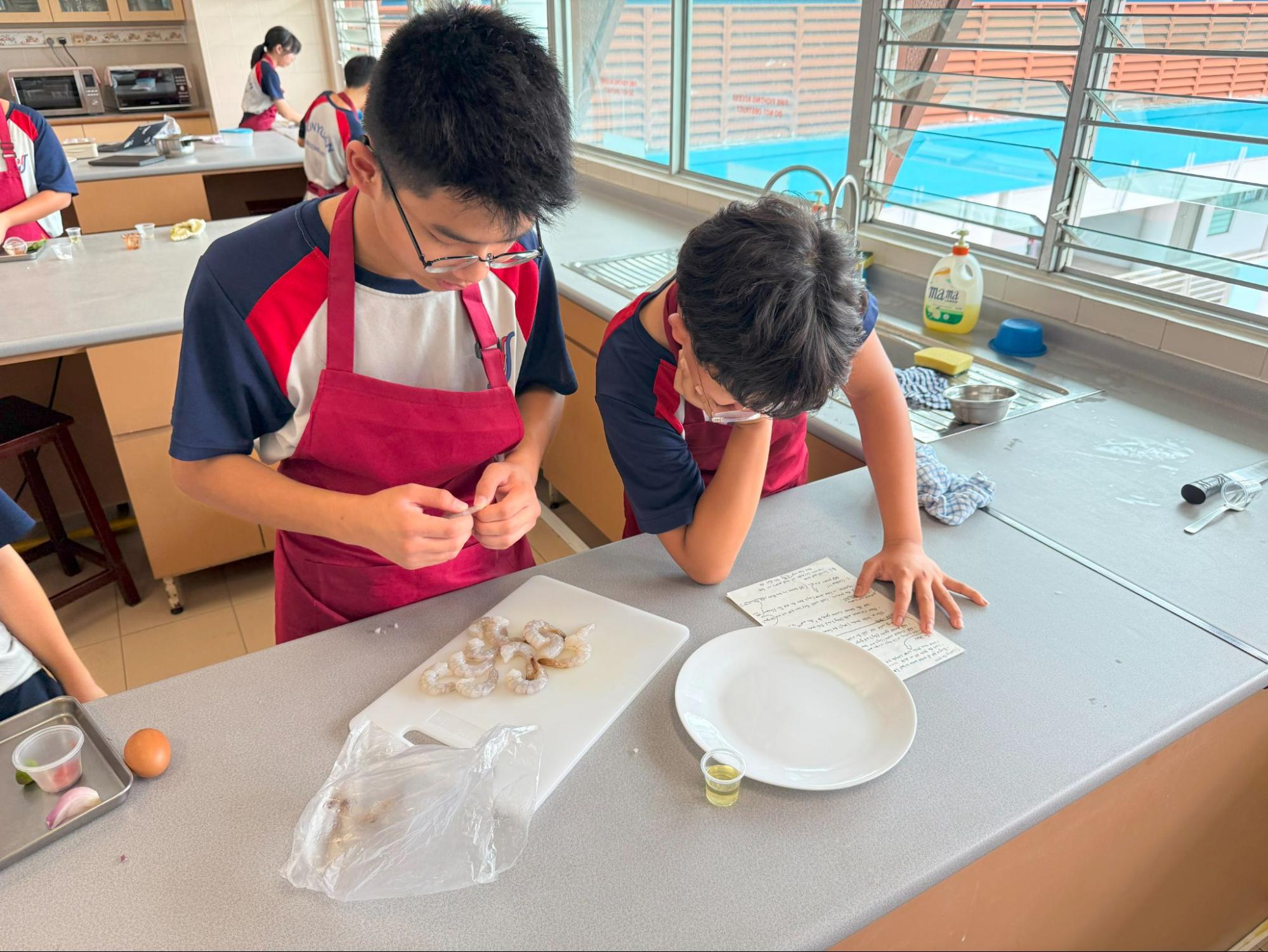 2 students learning to peel the prawn