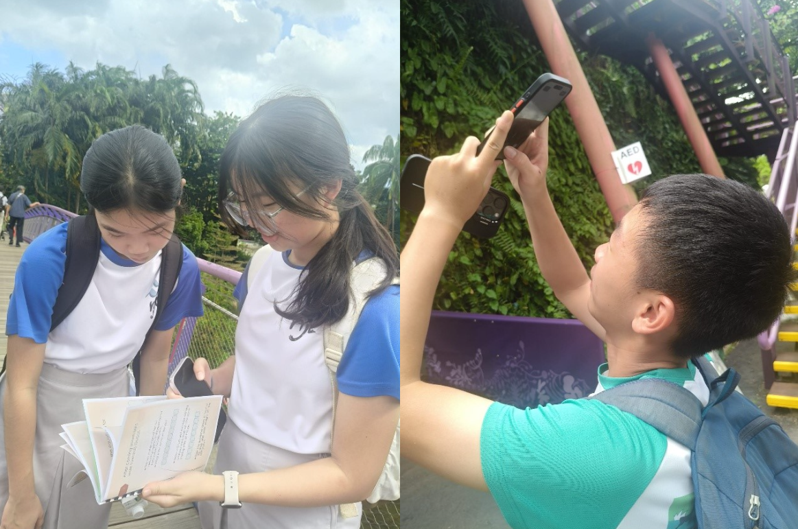 Two students review papers outdoors while a third holds a phone up to scan or photograph something above.