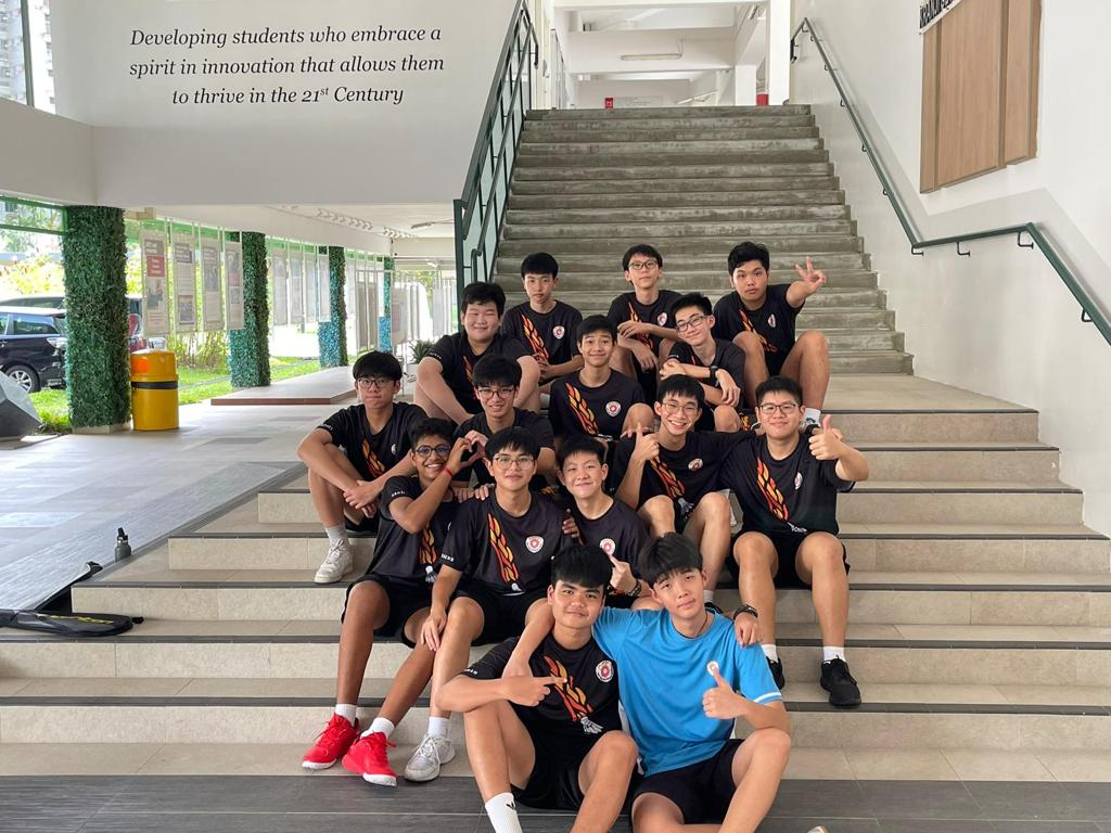 Badminton Boys team posing together at a staircase.