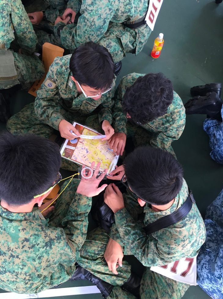 A group of students utilising a compass to read a map.