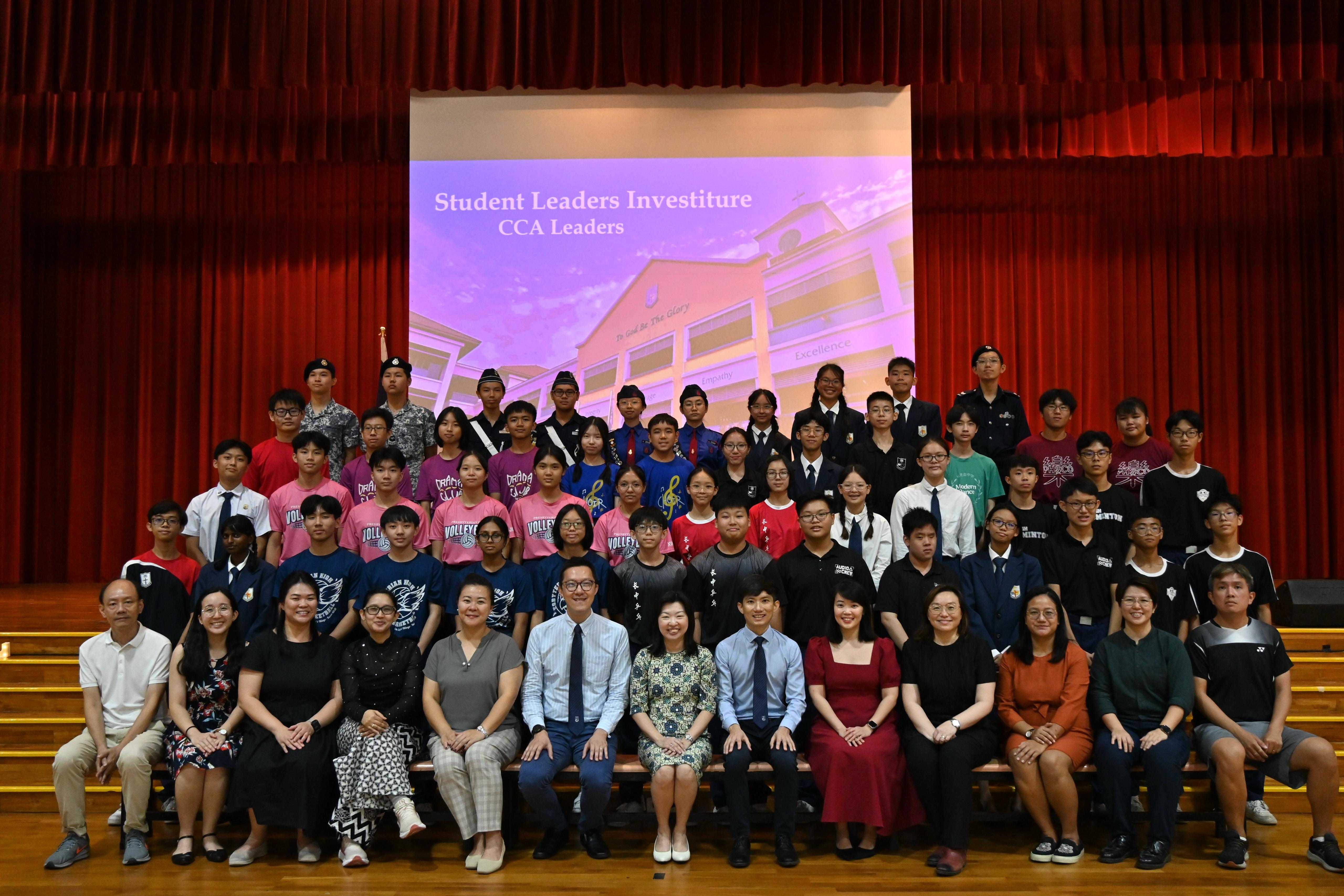 Group photo of students and teachers at a Student Leaders Investiture CCA Leaders ceremony on a stage.