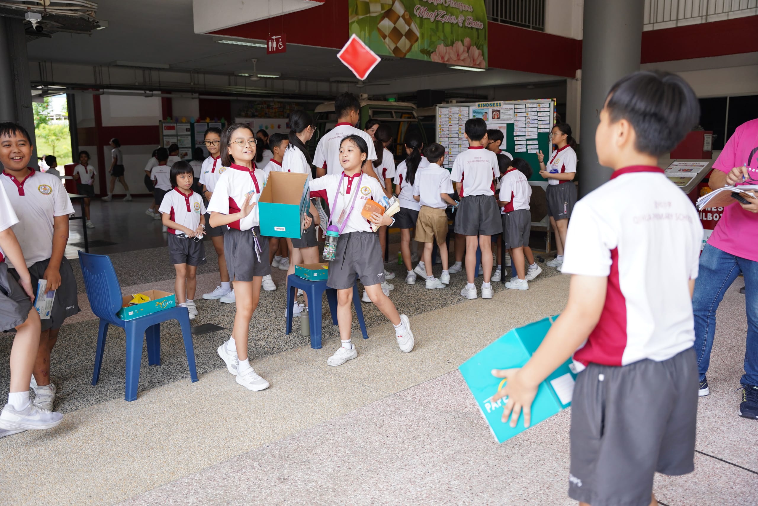 Student throwing a red item to her friend, playing catch