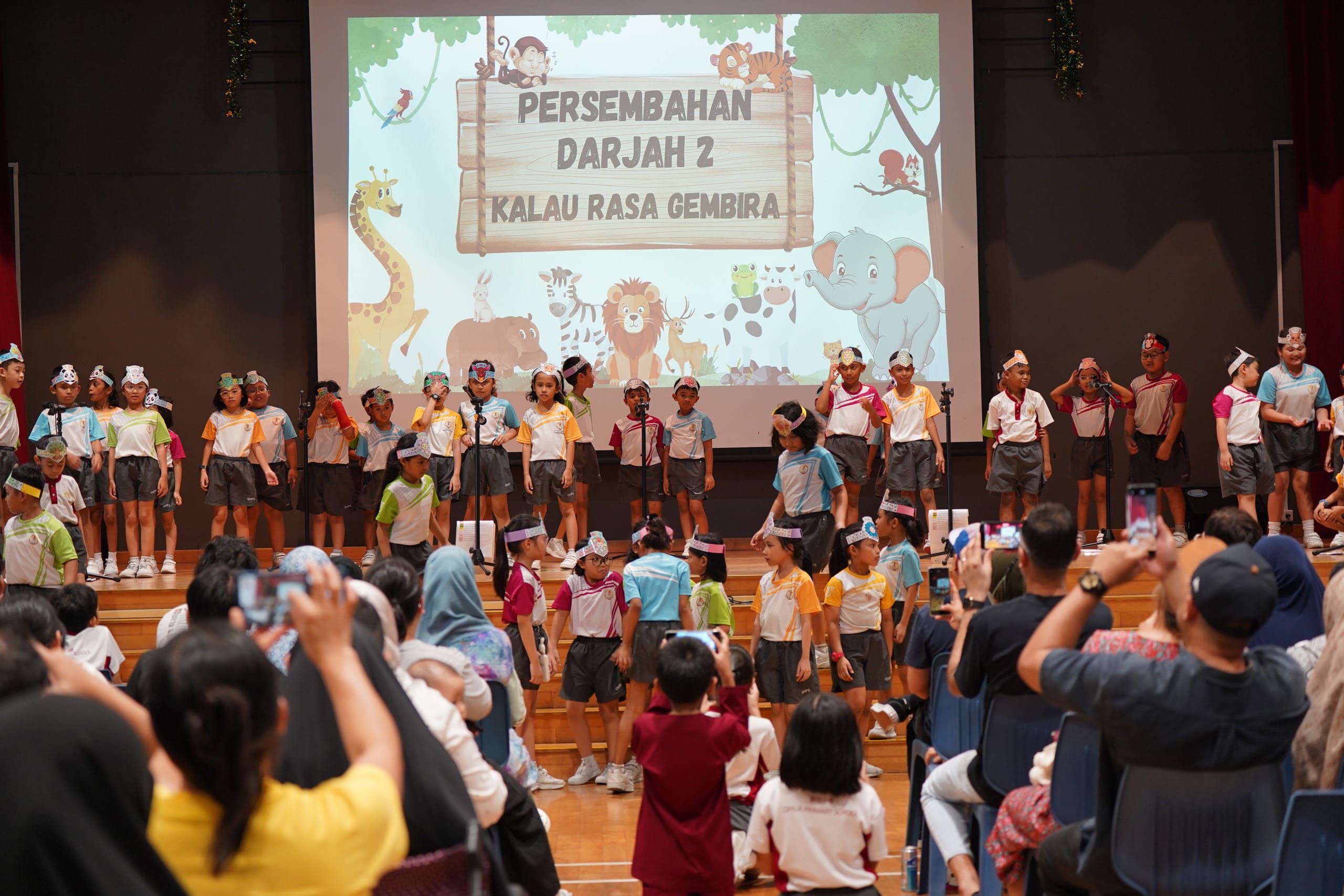 Students on stage, watched by parents below stage
