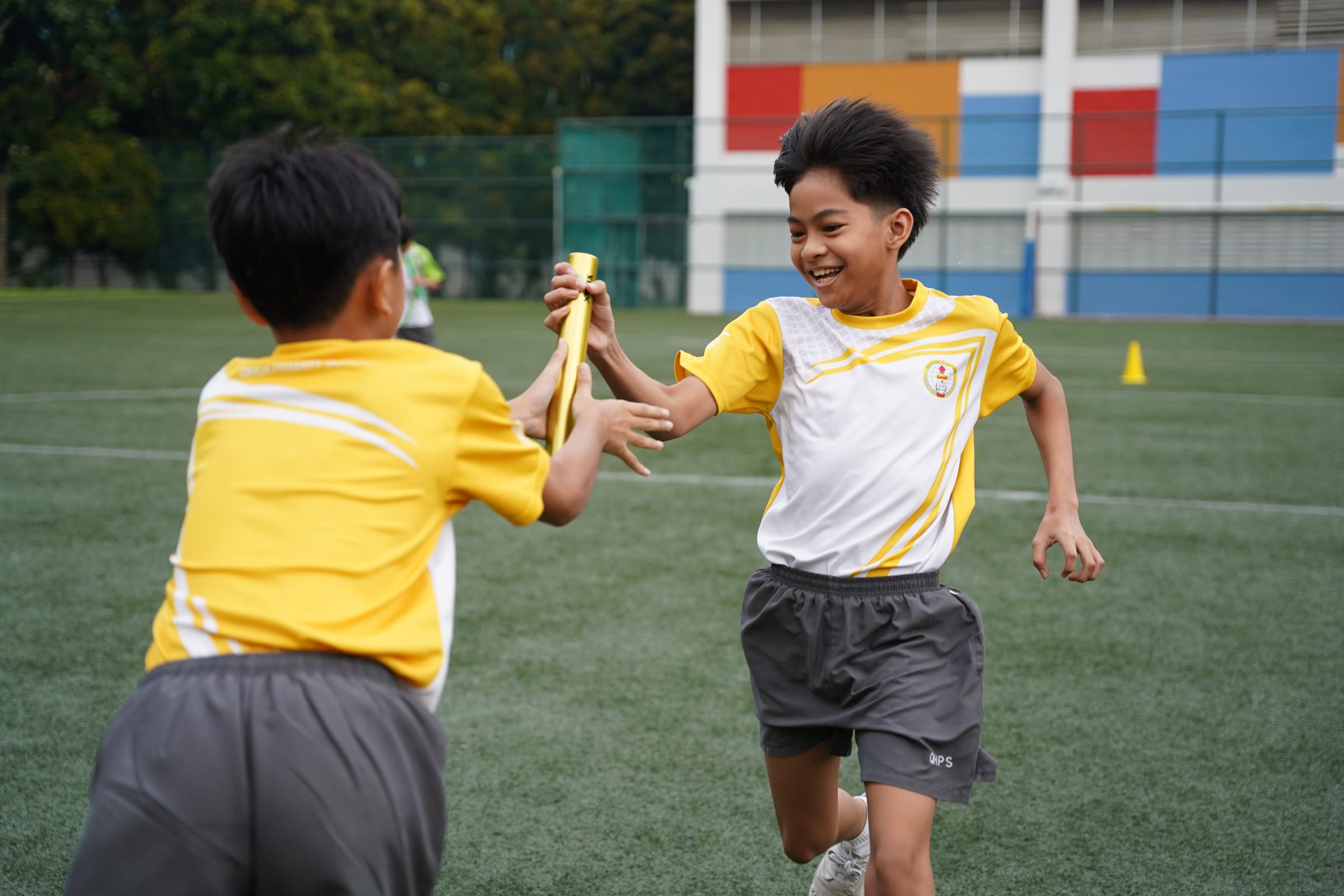 Student passing baton to classmate during relay race