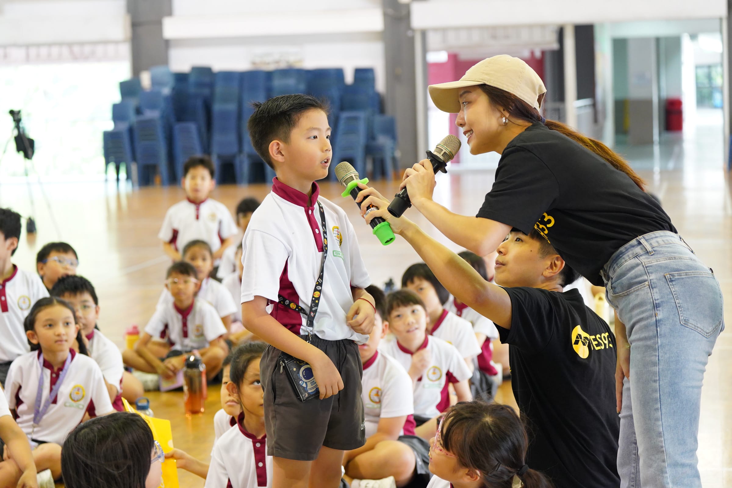 DJs from 933FM interviewing a boy in the school hall
