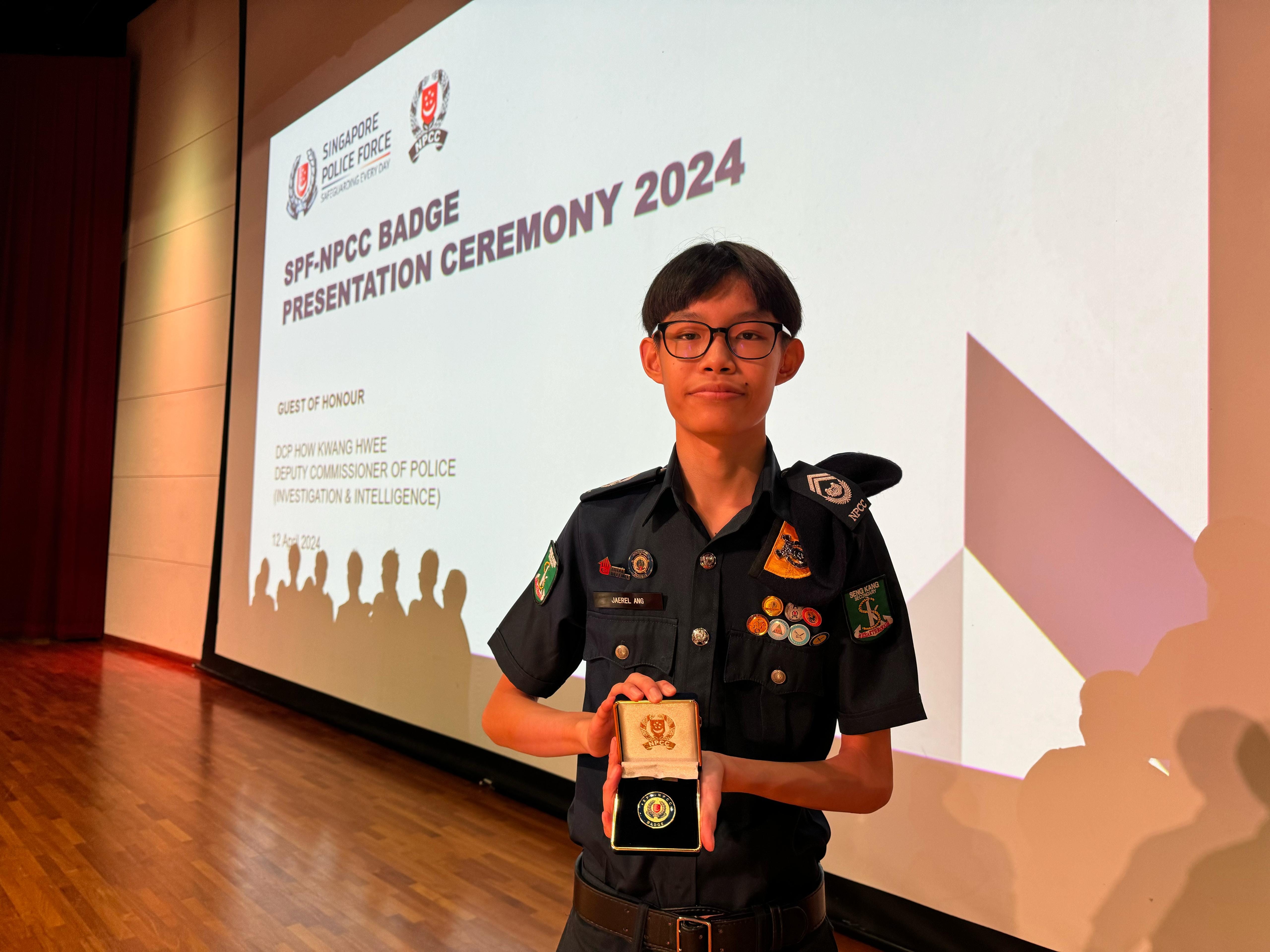 Young person in NPCC uniform holds a badge in a box at the SPF-NPCC Badge Presentation Ceremony 2024.