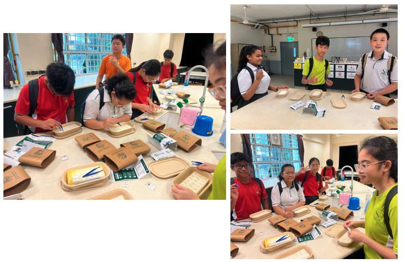 Students in uniforms gather around tables covered with kraft paper bags and food trays in a classroom activity.