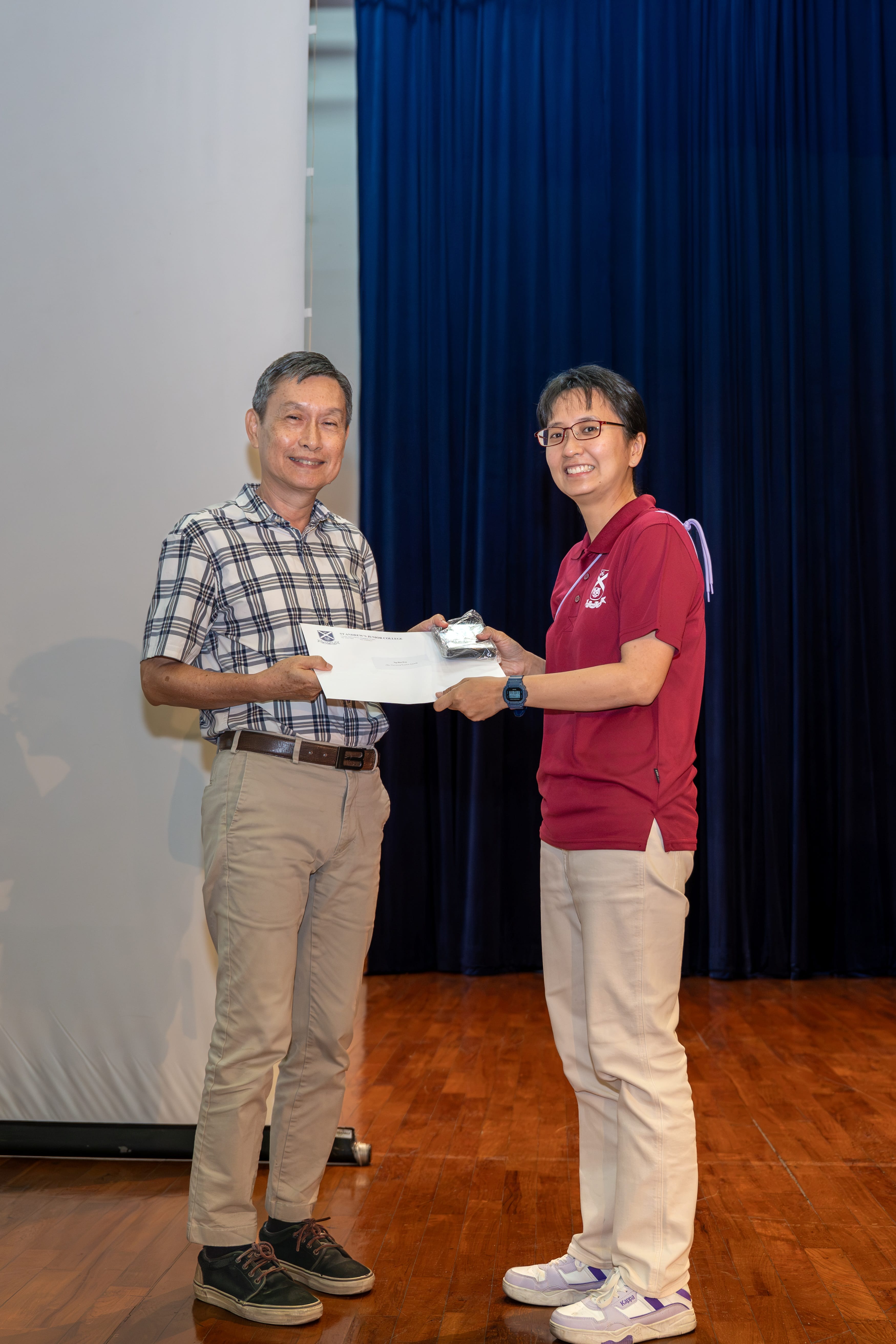 Ms Ng Hui Fen receiving her award from Deputy Principal of SAJC, Mr Ang Kheng San Cecil