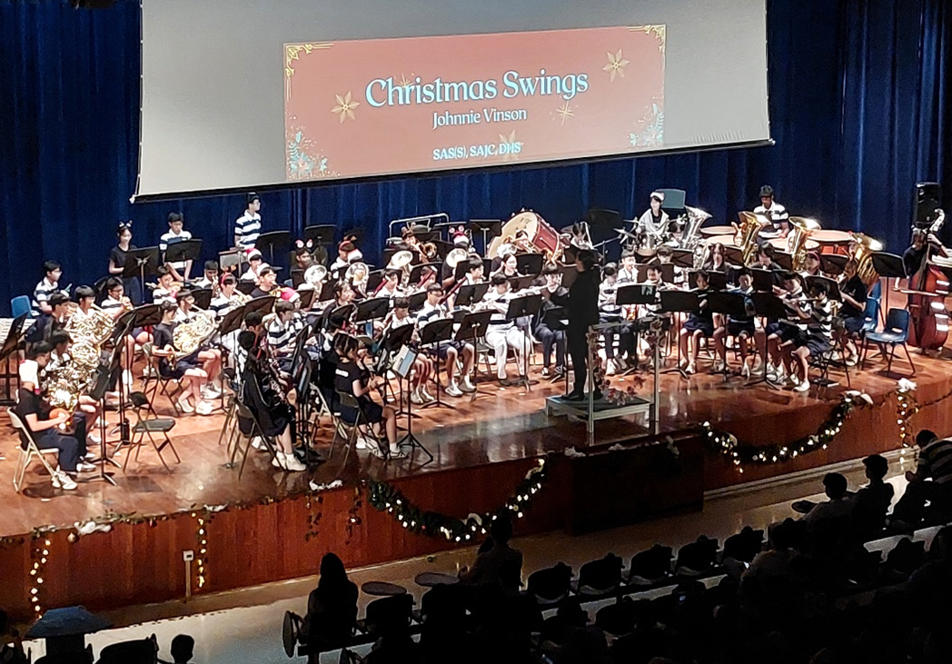 The Concert Band performing on stage at the College's Cultural Center at the 2025 SASS-SAJC Christmas Concert.