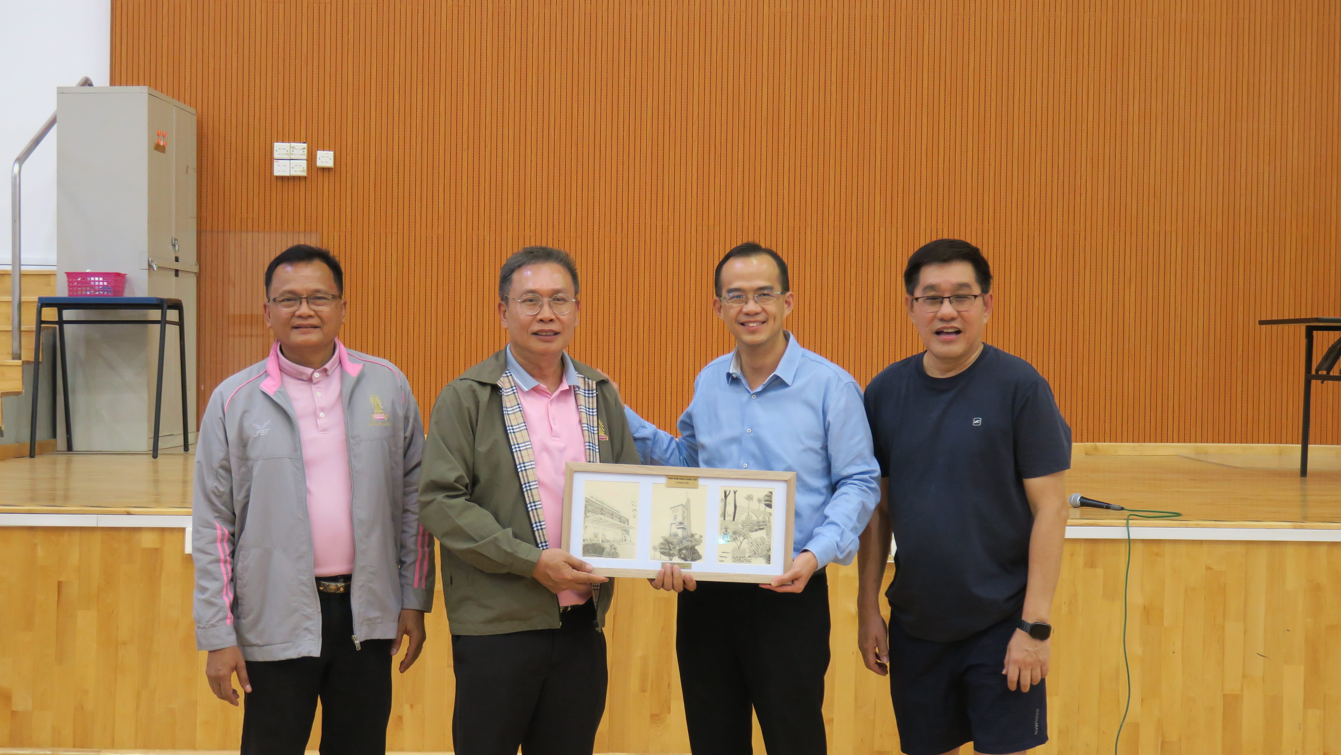 Mr Tham, Principal of St Andrew's Junior College, and Mr Chay, Head of Department, PE/CCA, presenting a piece of artwork to distinguished guests from Triam Udom Suksa School (Thailand)