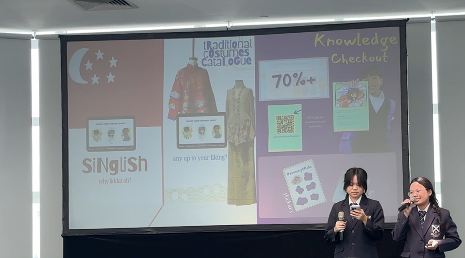 Two students in school uniforms present in front of a projected slide about Singlish and traditional costumes.