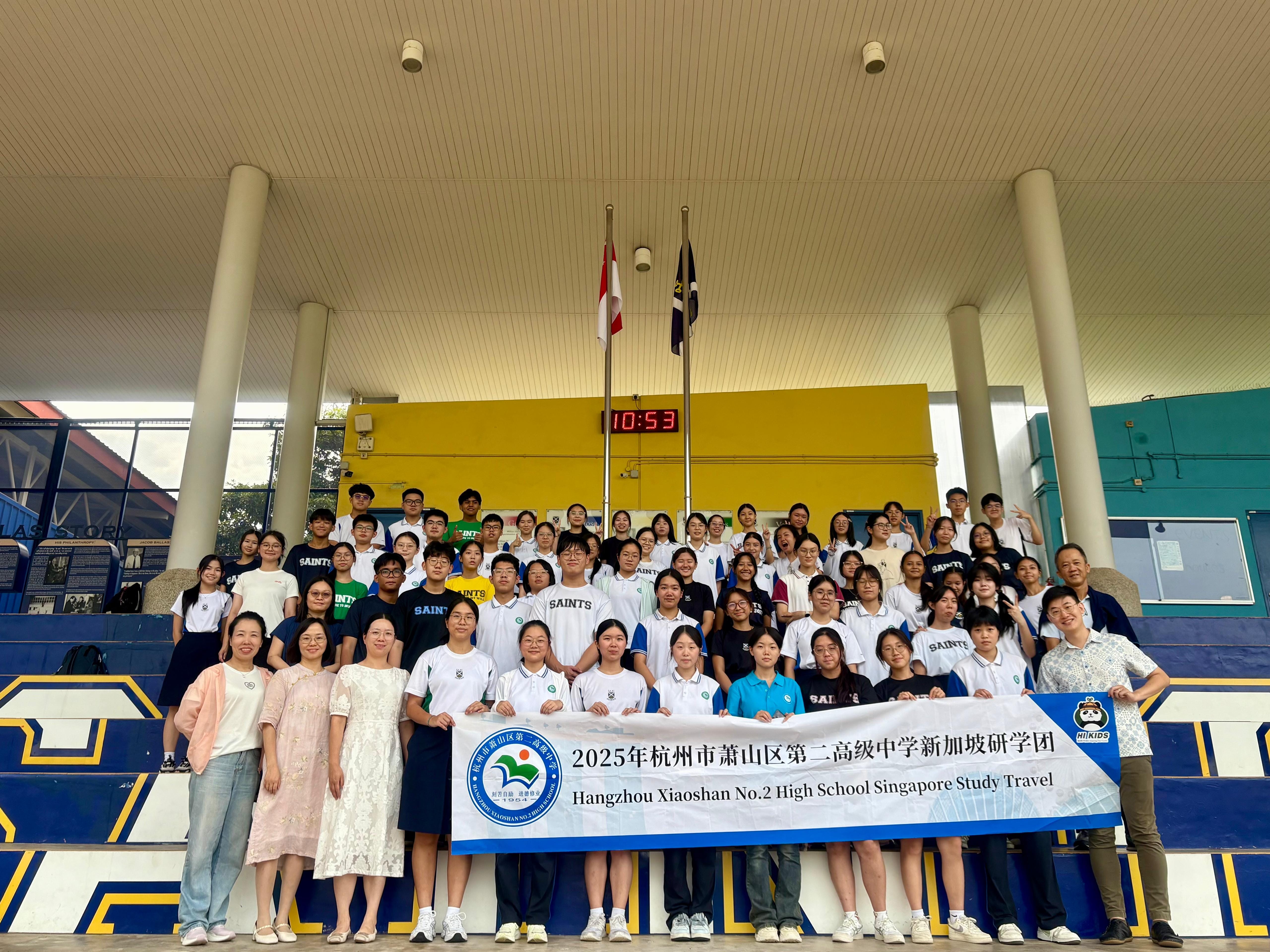 Large group of students and teachers pose with a banner reading Hangzhou Xiaoshan No.2 High School Singapore Study Travel.
