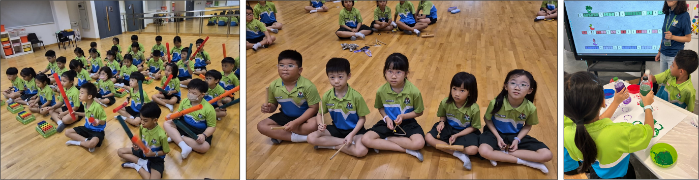 Young students in green uniforms sit on a wooden floor holding rhythm sticks and instruments during a music class.