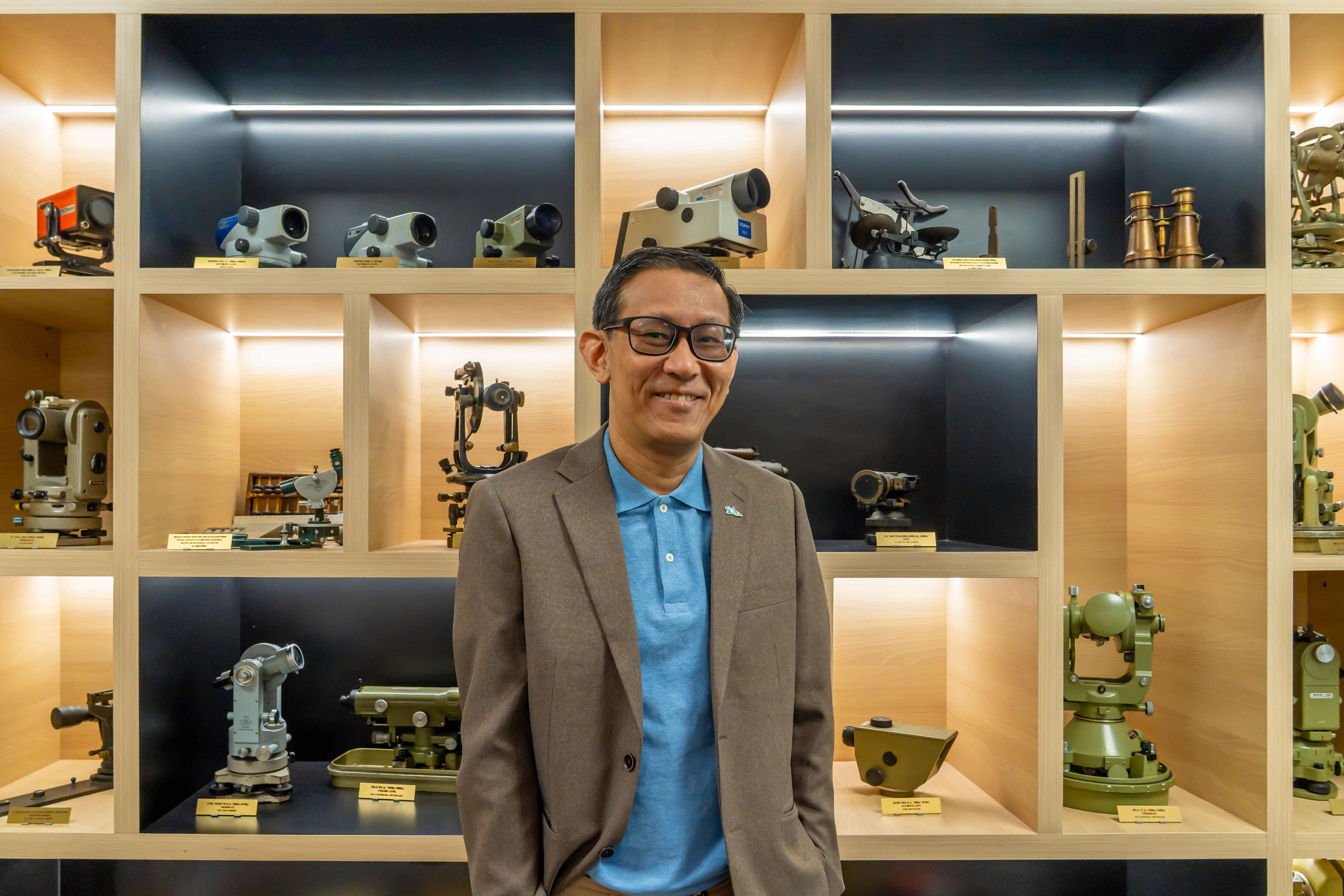 Chief Surveyor and Director of Survey & Geomatics Dr Victor Khoo with a display of vintage and modern survey equipment dating from 1850s to 2010s