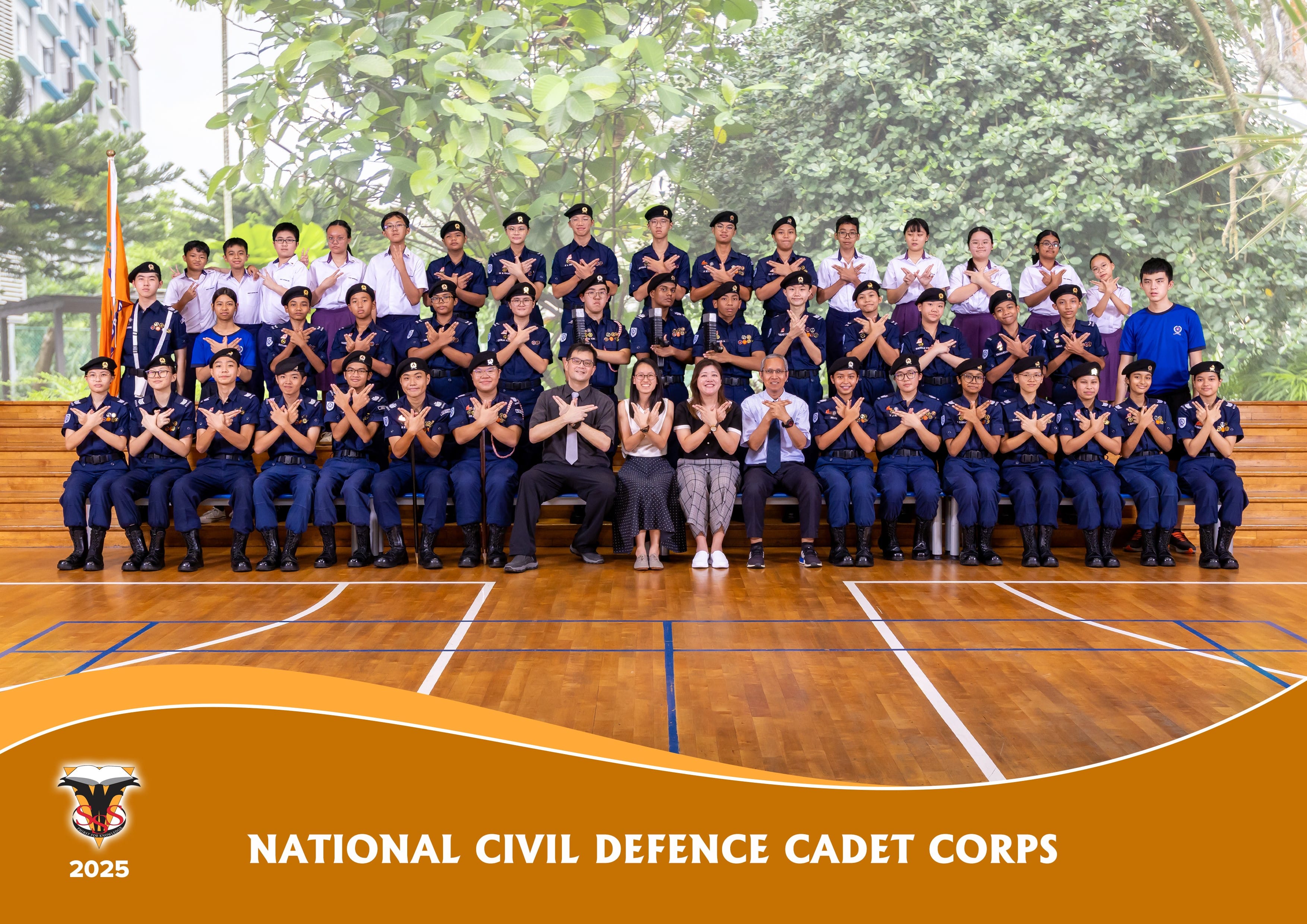 Group photo of National Civil Defence Cadet Corps, cadets in navy uniforms and berets posing indoors.