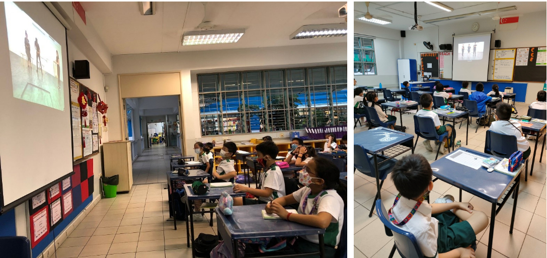 Students in uniforms and masks sit at desks watching a projected screen in two classroom views.