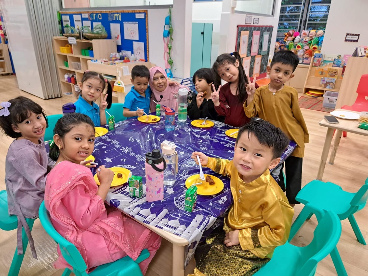 The children were invited to make a visit at Cikgu Ju’s “house”, where they received a warm welcome. They practised giving a salam with her and had a wonderful time enjoying Hari Raya treats and delightful company.