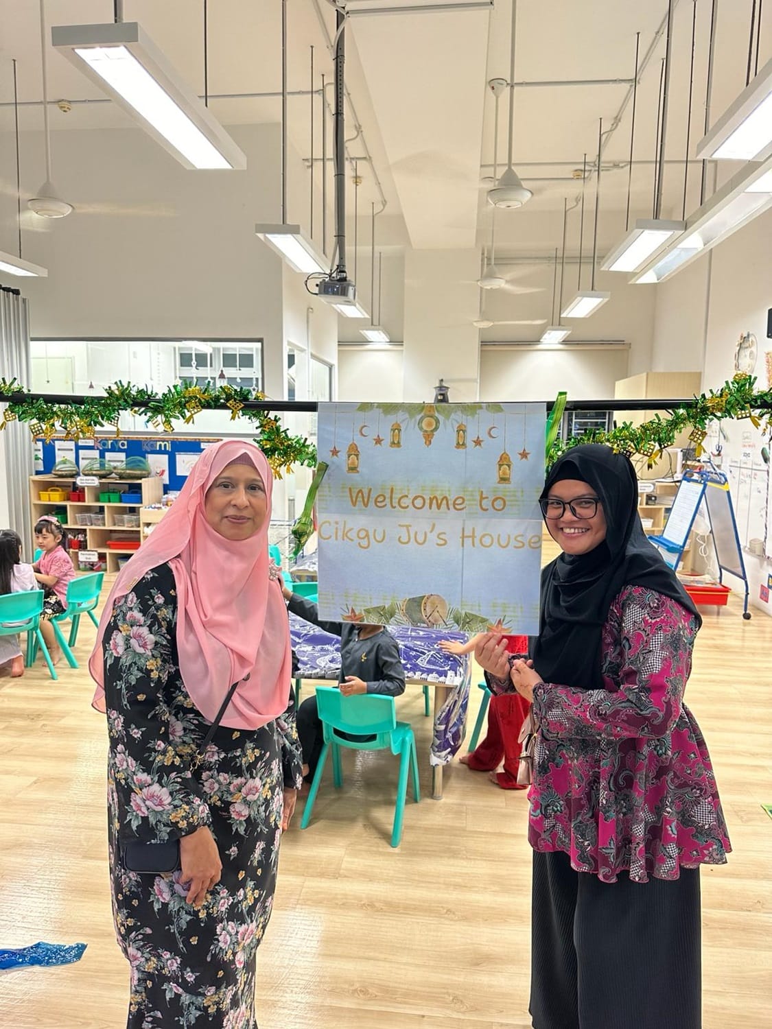 The children were invited to make a visit at Cikgu Ju’s “house”, where they received a warm welcome. They practised giving a salam with her and had a wonderful time enjoying Hari Raya treats and delightful company.