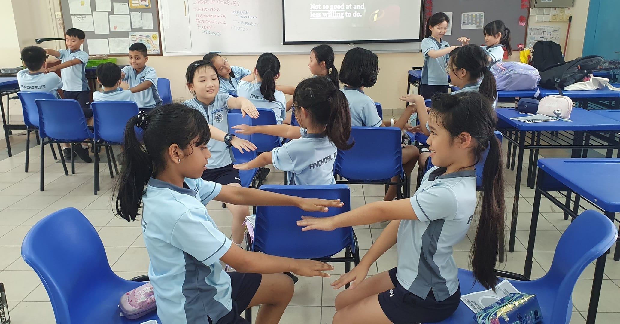 Primary school student leaders sitting at a desk and working together a project during a leadership training workshop.