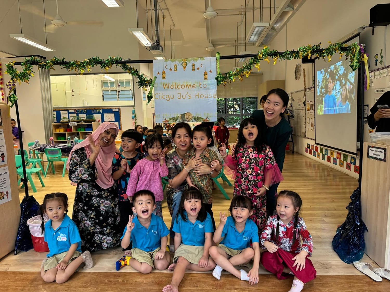 The children were invited to make a visit at Cikgu Ju’s “house”, where they received a warm welcome. They practised giving a salam with her and had a wonderful time enjoying Hari Raya treats and delightful company.
