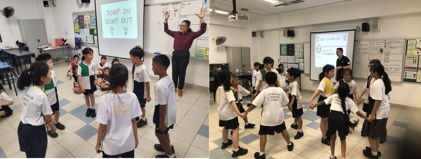 Primary school students in white uniforms play a circle game led by teachers, with a Jump In Jump Out slideshow on the board.