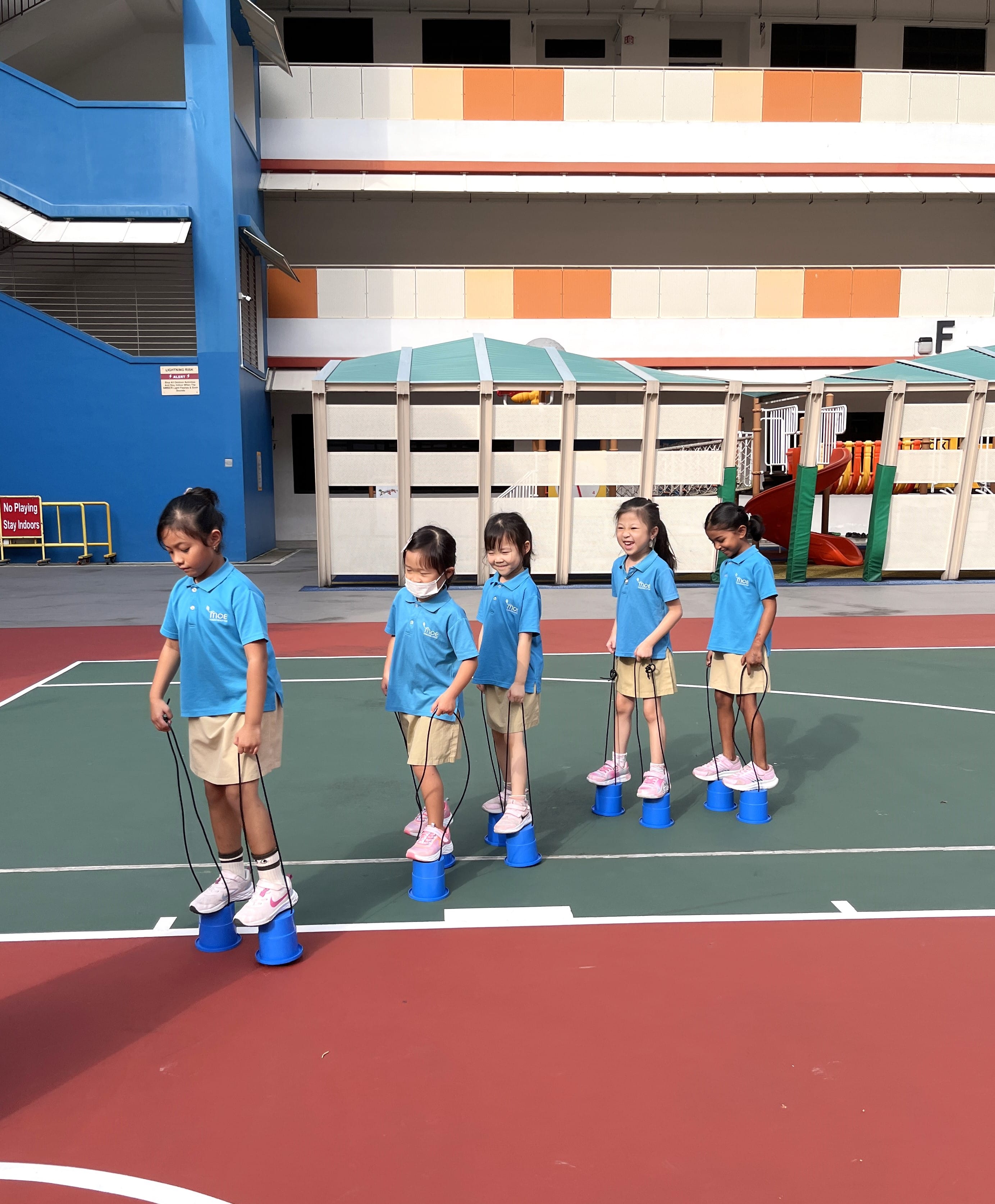 Children playing in the basketball court, learning new skills