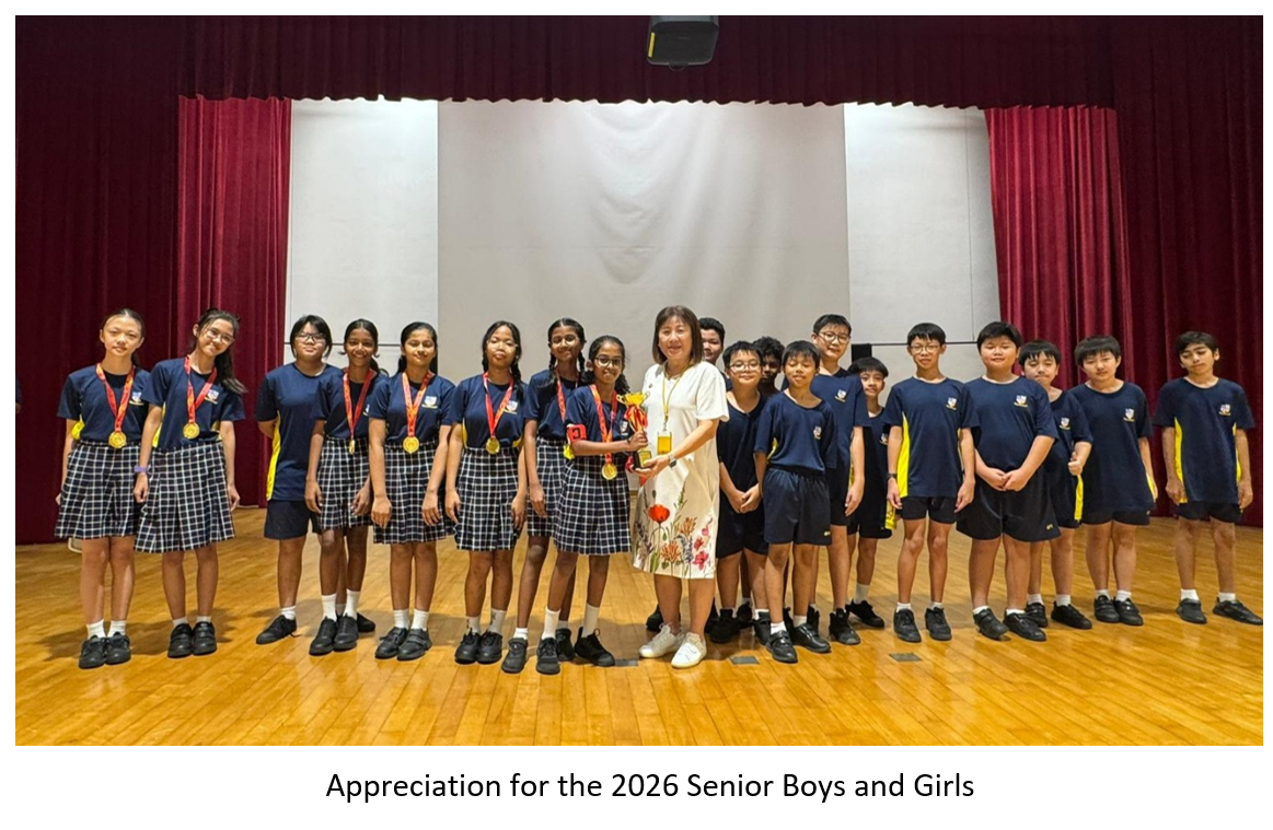 Principal holds a trophy with students wearing gold medals on a school stage.