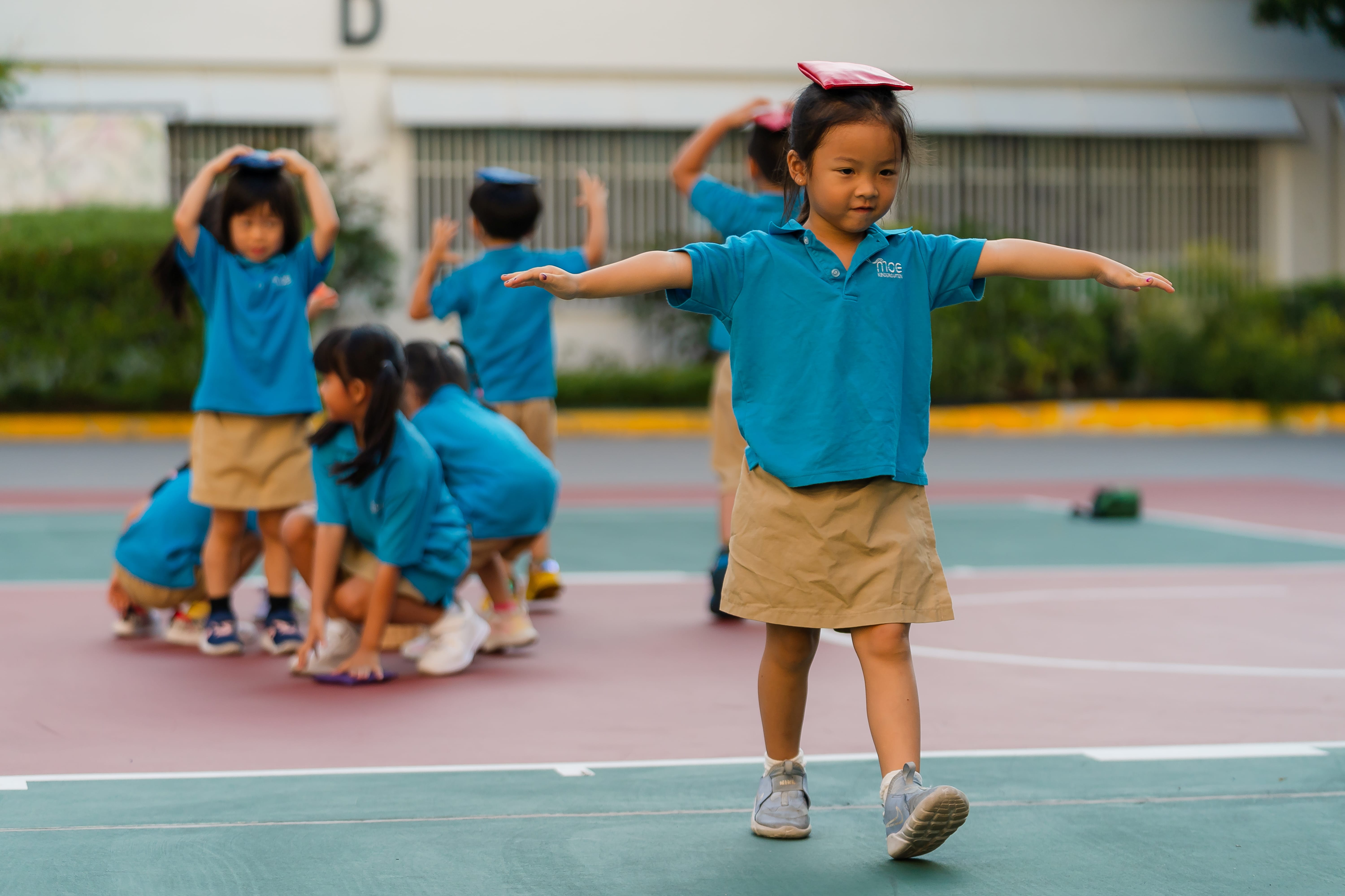Children playing in the basketball court, learning new skills
