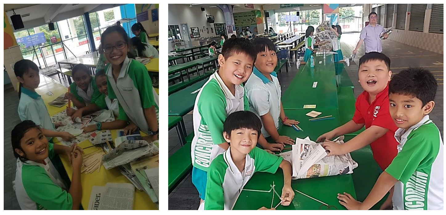 student smile at the camera while working on newspaper craft projects.