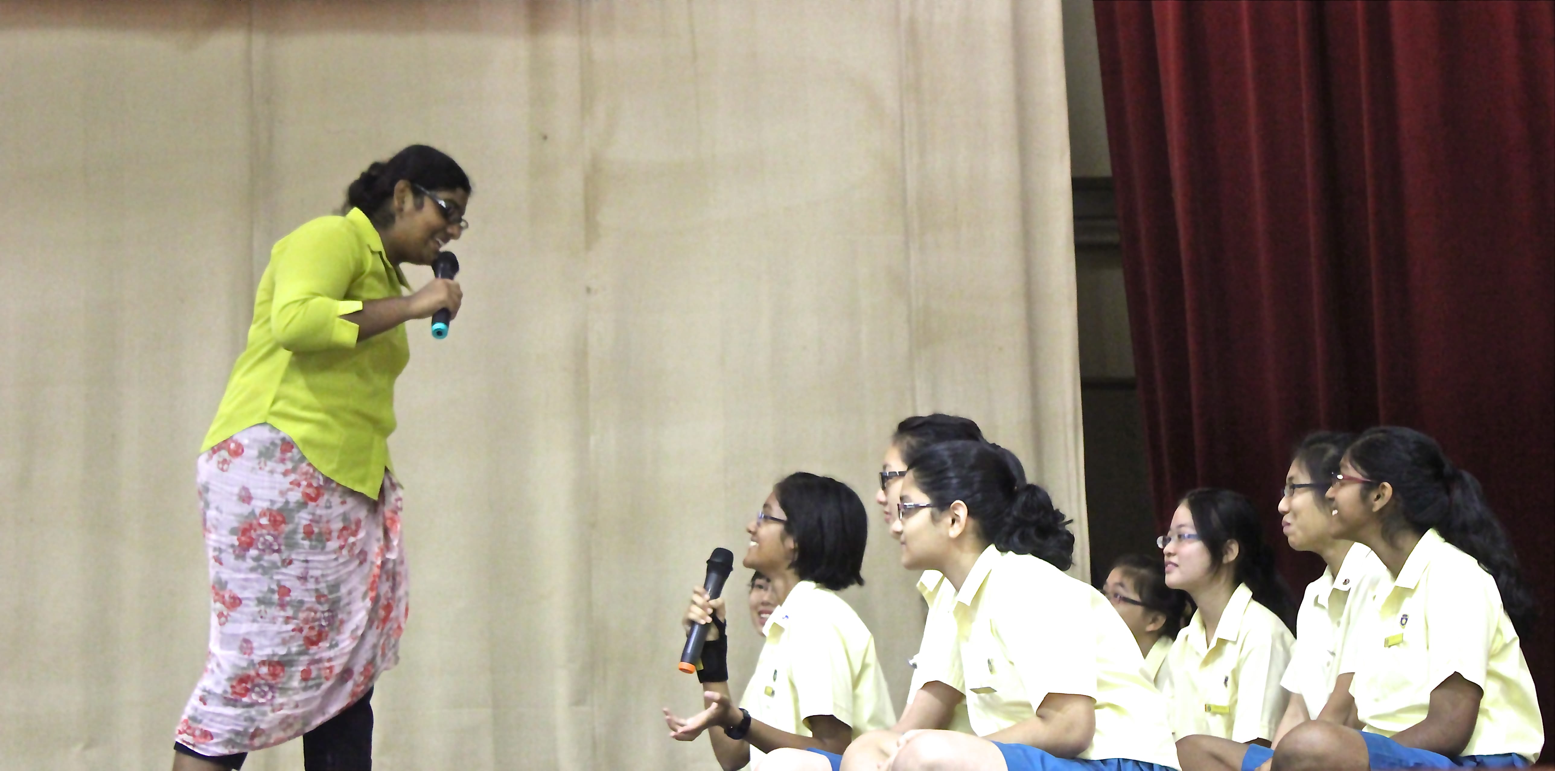 A woman asking questions toward a group of students