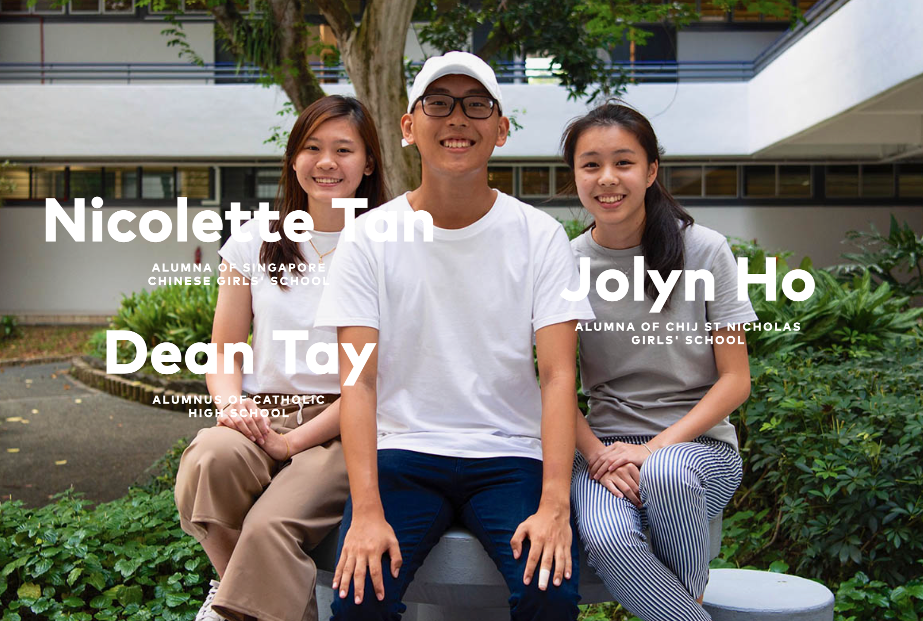 Three smiling students, Nicolette Tan, Dean Tay, and Jolyn Ho, sit outdoors in front of a school building.