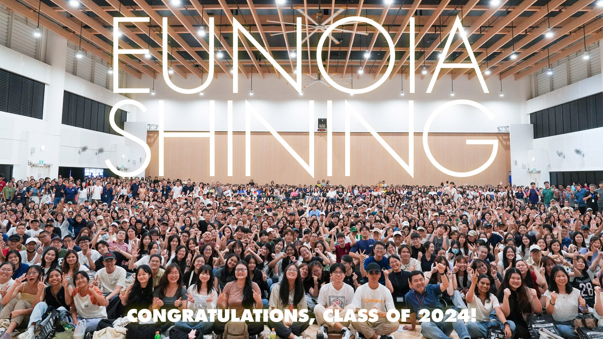Large group of students posing in a hall with text reading Eunoia Shining and Congratulations Class of 2024.