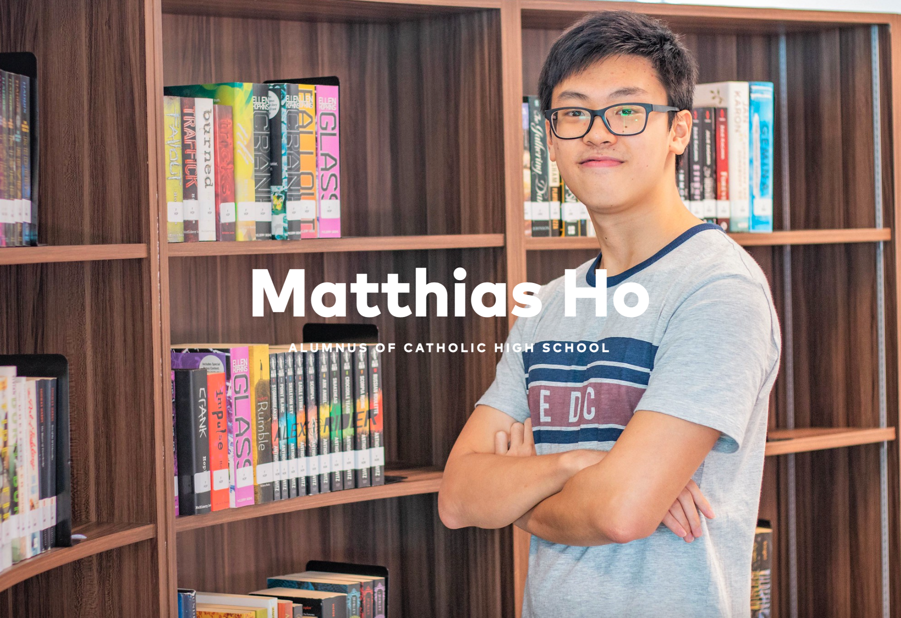 Young man with glasses stands arms crossed by library shelves; overlaid text reads Matthias Ho.