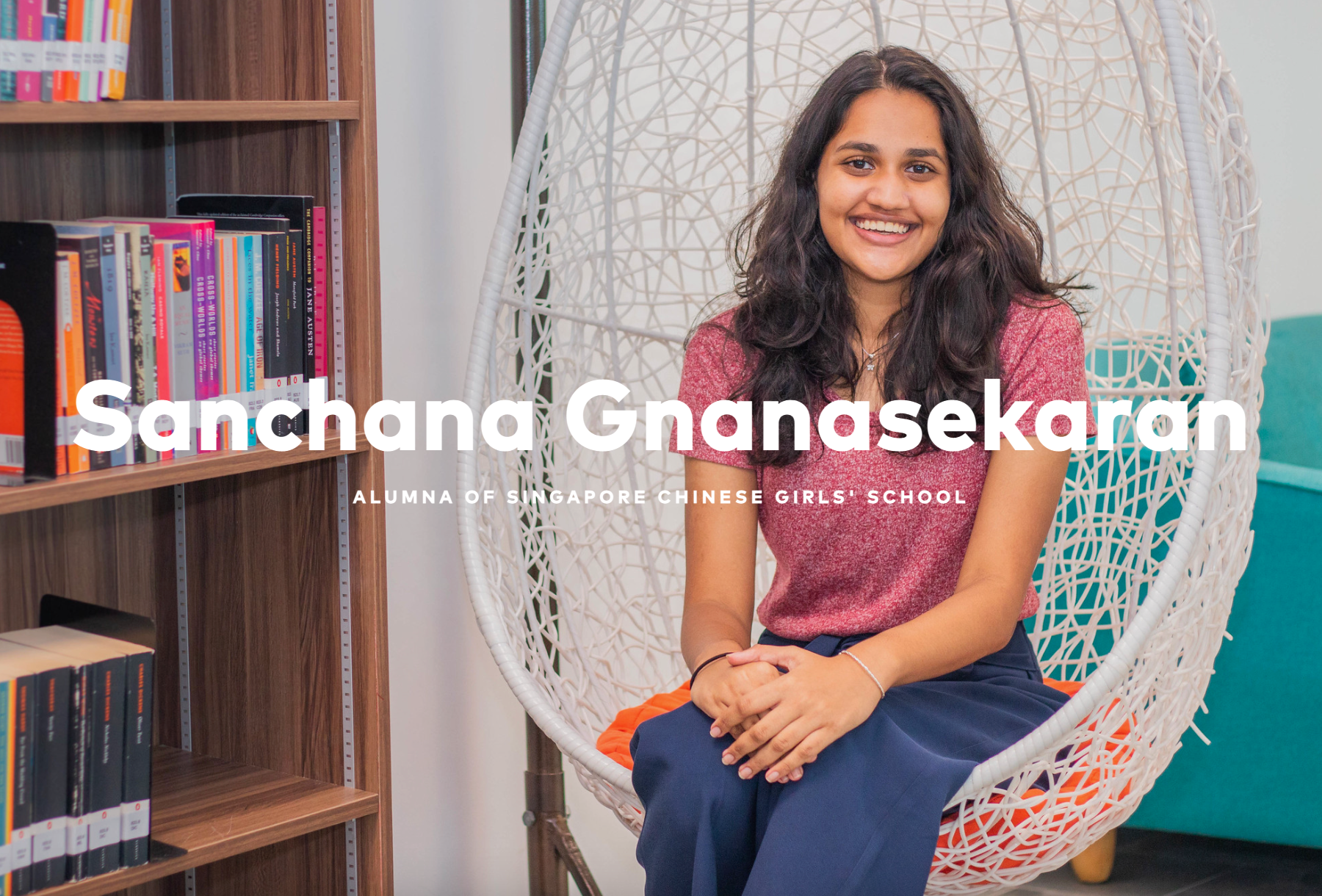 Smiling woman seated in a white hanging chair beside a bookshelf, with large name text across the photo.