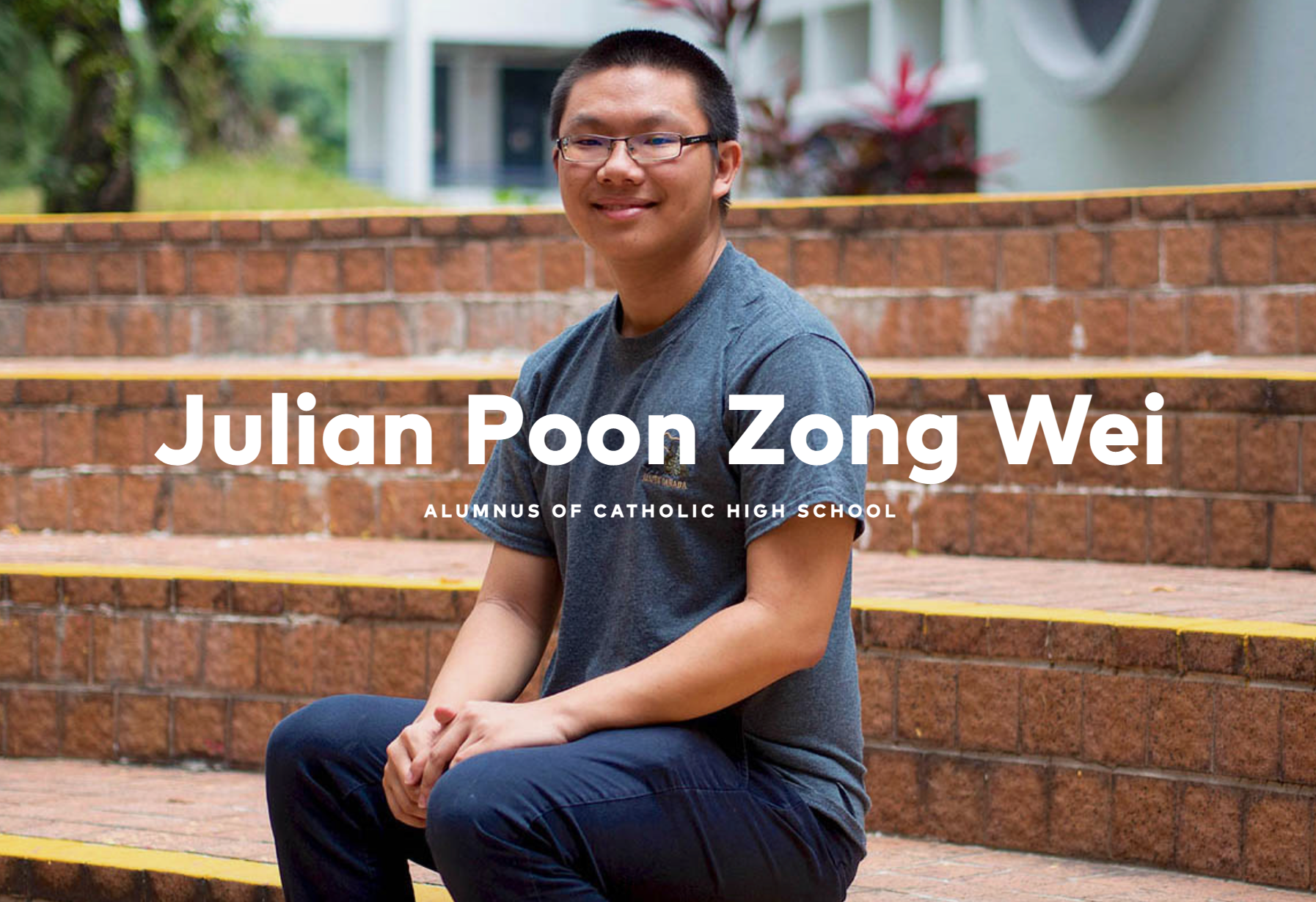 Young man with glasses in a gray shirt sits on brick steps, labeled Julian Poon Zong Wei, alumnus of Catholic High School.