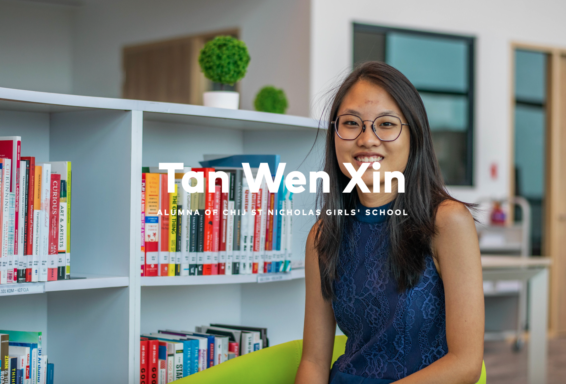 Young woman with glasses smiling beside a colorful bookshelf, labeled Tan Wen Xin, alumna of CHIJ St Nicholas Girls' School.