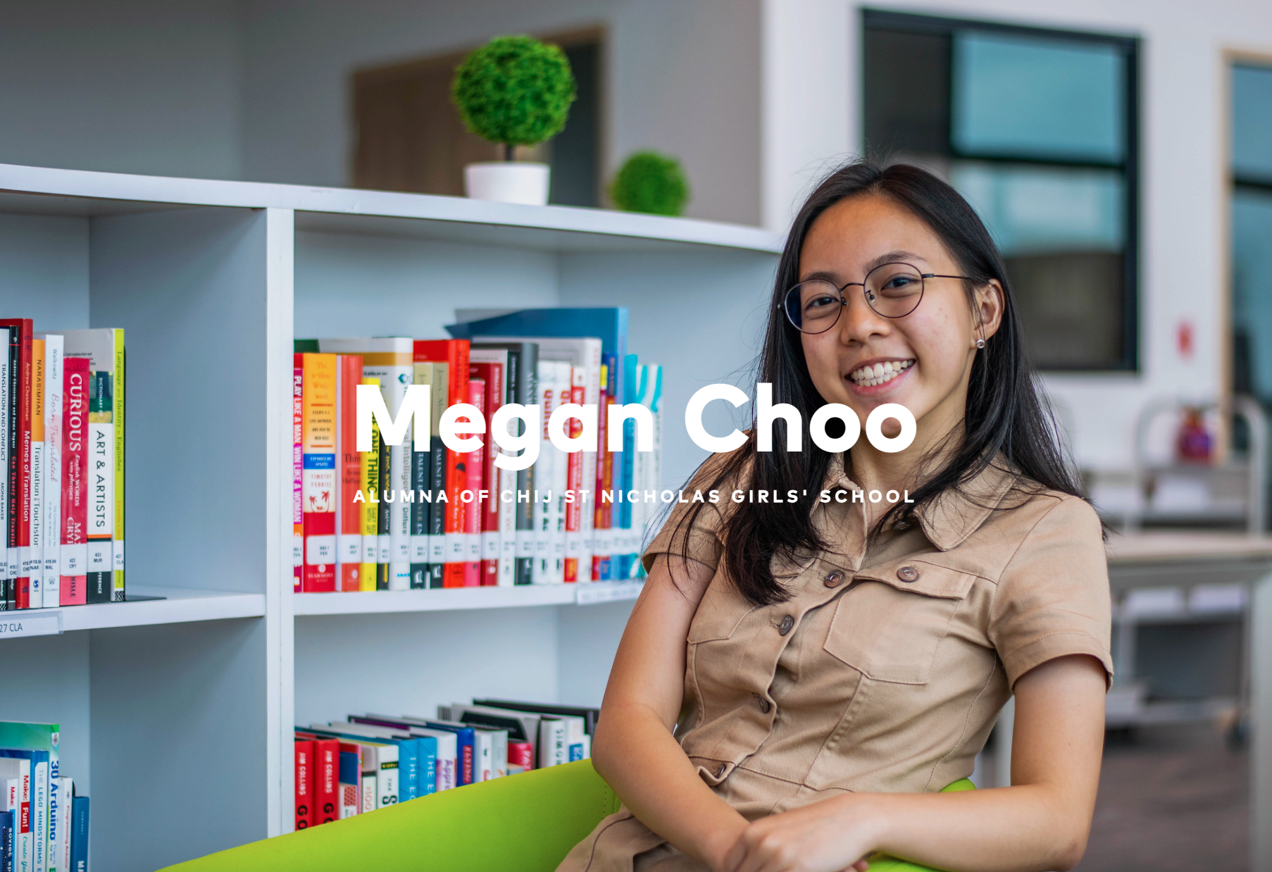 Smiling young woman with glasses sitting in a library, labeled as Megan Choo, alumna of CHIJ St Nicholas Girls' School.